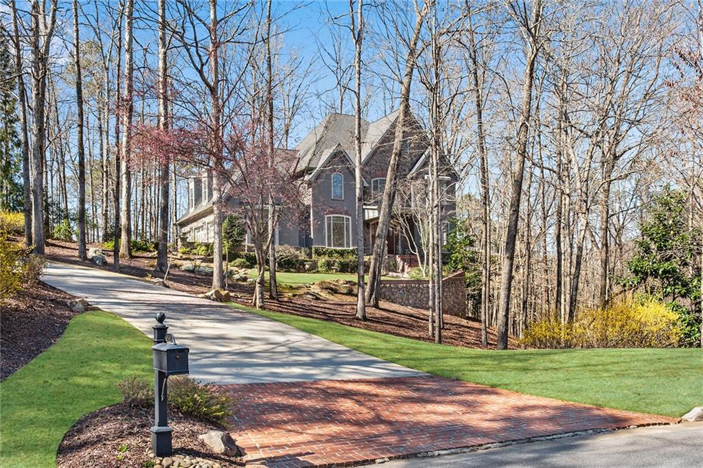 Situated on a 1.21-acre lot at the base of Kennesaw Mountain. Custom built 4 bdrm, 3 full, 2 half bath Country French Estate in a private, gated community in the Marietta Square area. Completely painted inside with all the finishes you would expect in such a sophisticated home. Just minutes to Kennesaw Mountain, Marietta Square, Marietta Country Club and Cobb County schools of excellence: Westside, Marietta Middle & High. The sprawling front lawn leads to an inviting front porch overlooking both a private stream & gorgeous lake with water feature. Spectacular views of nature surround this home. Inside the home you’ll find a grand, 2-story foyer w/ gorgeous staircase. 10-ft. ceilings on the main level w/ hardwoods & heavy millwork throughout. Banquet sized Dining rm w/ Butler’s pantry opens to a gourmet Kitchen w/ slate floors, custom cabinetry, granite counters, center island, large breakfast bar & a large eat-in Kitchen area that overlooks a tranquil backyard. New SS refrigerator & dishwasher. Kitchen is open to the Family rm that has tons of natural light streaming in from the floor to ceiling windows. Custom built fireplace with newer Fyre gas logs. Custom stained glass windows highlight the main floor office. One of the show-stoppers of this home is the French doors that lead out to the flagstone patio which runs the length of the home. This home is perfect for entertaining! The oversized primary bedroom is upstairs & has gorgeous window seats, his & her closets & a spa-like master bathroom w/ a new air tub, double vanities w/ marble countertops, a large walk-in shower & a gorgeous antique chandelier. New carpet upstairs. Three additional bedrooms-one is a huge teen/in-law suite. Rear stairs. Full unfinished terrace level that is perfect for a workshop or finished to your specifications. Three car garage.