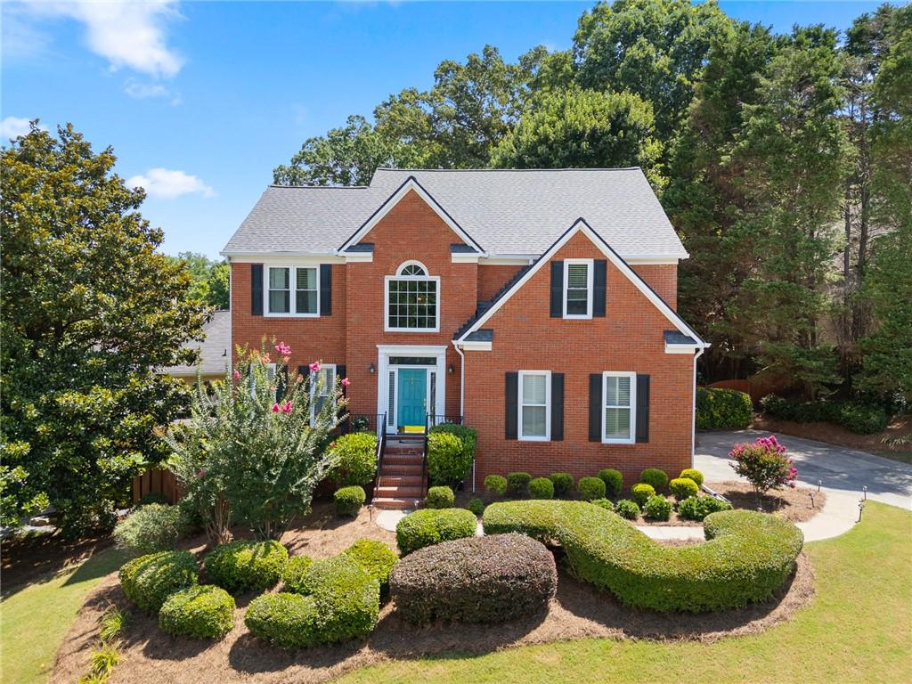 Welcome to 4059 Vinings Mill Trail – Located in the Sought-After Olde Vinings Mill Community. This beautiful, 5-bedroom, 3.5-bath home sits on a premium corner lot with stunning curb appeal, is just steps from community amenities including a pool, playground, and tennis courts. As you enter, you're welcomed by a two-story foyer and gleaming hardwood floors throughout the main level. The open-concept kitchen features granite countertops, a gas range, custom cabinetry, and an extended island overlooking the breakfast nook and spacious living room. Enjoy natural light from the wall of windows at the rear of the home, offering peaceful views of the lush, garden-style backyard. Additional main floor highlights include a formal dining room and a separate sitting room or flex space. Upstairs, the oversized primary suite includes a cozy reading nook, walk-in closet, and an updated en suite bath with double vanity and walk-in shower. Three additional bedrooms and a full bath offer flexible space for guests, children, or a home office. The fully finished basement is perfect for entertaining, relaxing, or multi-generational living. With a large bedroom, full bath, and walk-out access, it’s ideal for an in-law suite. There's also a generous unfinished storage area. Perched on a gentle hill with a flat driveway, this home is conveniently walkable to Ivy Walk’s shops and restaurants, close to the Silver Comet Trail, and just minutes from I-285 and I-75 for easy commuting. Don't miss this incredible opportunity — schedule your showing today!