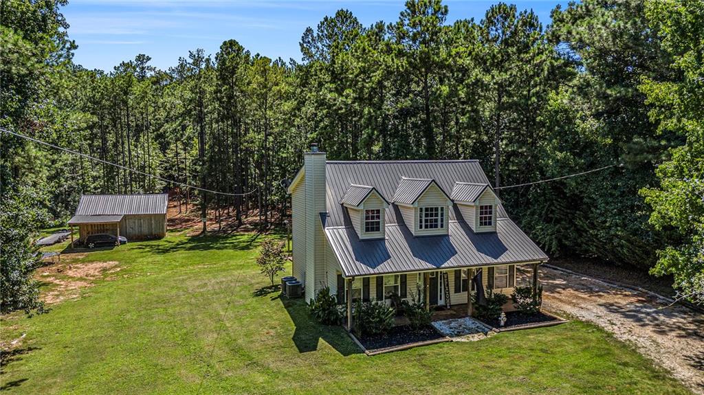 Welcome to this charming Monticello home, offering the perfect blend of Southern charm, modern comfort, and peaceful privacy. Upon entry, you're greeted by soaring vaulted ceilings and a striking staircase leading to the upstairs guest suites. The main level features a spacious owner’s suite complete with a walk-in closet and a double vanity bathroom. The open-concept family room flows seamlessly into the kitchen, providing scenic views of the property—an ideal space for relaxing or entertaining. Durable wood-look tile flooring extends throughout the main level, combining style and practicality. Upstairs, you’ll find two generously sized guest rooms, each with dual closets, and a shared full bathroom. Step outside to your private rear porch and backyard retreat, perfect for cookouts or relaxing evenings around the fire pit. A portion of the yard has been clear-cut and fenced, making it an excellent area for pets or small livestock. A standout feature of this property is the impressive 30' x 20' workshop with POWER—ideal for hobbyists, professionals, or anyone in need of serious workspace. It’s built on a concrete slab engineered to accommodate an automotive lift and includes a second entrance off Cook Road for added accessibility.
Additionally, a 10' x 10' utility building provides extra storage or workspace. Located just minutes from downtown Monticello and only half a mile from a public boat slip on Jackson Lake, this home offers both convenience and tranquility. Recent updates include an updated roof and HVAC system within the past couple of years, and a brand-new water heater installed this year. Don’t miss your chance to make this exceptional property your own!