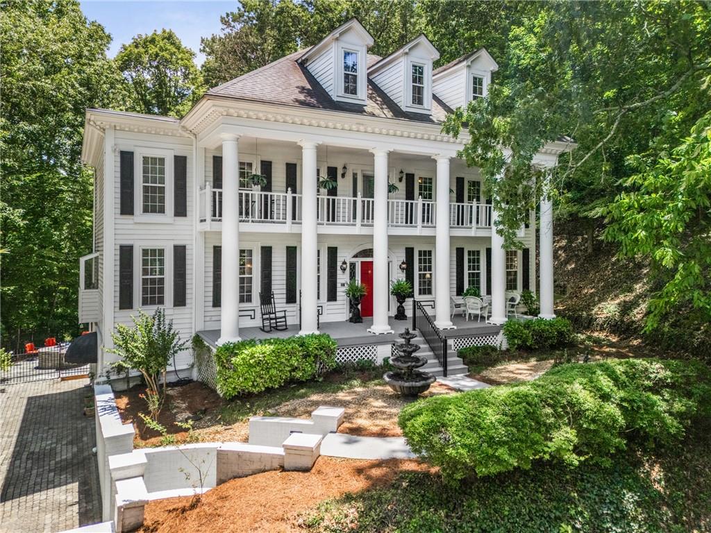 Introducing a captivating Greek Revival residence in the highly sought-after Huntcliff community. This picturesque home, defined by its elegant double front porches and perfectly elevated position, the home enjoys tranquil, tree-canopy views and exceptional privacy, exudes timeless sophistication and charm. A beautifully laid Bergerac paver driveway with parking for up to six cars sets the tone for the elegance found throughout. Step inside to discover a newly renovated, spa-inspired primary bathroom featuring sleek white freestanding cabinetry, white and gray quartz countertops, Moen faucets and sinks, Carrera white marble flooring, and a stunning picture window with motorized shade. Enjoy the oversized shower with Bluetooth fan and speaker, new lighting throughout—including sconces, chandelier, and modern backlit mirrors—plus a linen closet with sliding door and new toilet. This meticulously maintained home includes 48 brand-new windows, a climate-controlled garage with newly surfaced flooring, professional-grade shop mats, new garage doors, Leaf Guard gutters and new hardwood floors in all upstairs bedrooms. A Navien high-efficiency tankless water heater ensures endless hot water, while the flagstone patio boasts a newer outdoor kitchen with a Lion built-in grill and sink, plus a natural gas stacked-stone fire pit with integrated dining-height flagstone table—ideal for entertaining. The spacious entrance foyer is flanked by a formal dining room and living room, creating a warm and welcoming first impression. A Gentlemen’s Library with brick fireplace, a full wall of built-in bookshelves, French doors open to a composite deck with new railings, private updated half bath provides a cozy retreat. The fireside grand room features a wet bar and opens seamlessly to the heart of the home—an expansive chef’s kitchen flooded with natural light. Highlights include a greenhouse window over the sink, an abundance of cabinetry and counter space, work island, Dacor gas cooktop, stainless steel appliances, wine cooler, two sinks, and two dishwashers. Adjacent is a large, vaulted sunny breakfast room with skylights—perfect for casual dining. A spacious laundry room offers a utility sink, built-in cabinets, and a hanging area, while a formal powder room adds convenience. Upstairs, the owner’s suite is a serene haven with tray ceilings, a sitting area, and direct access to a private covered porch overlooking the peaceful surroundings. The newly renovated ensuite bath is a luxurious escape. Three additional bedrooms offer ample space—two share an entirely brand new Jack and Jill bathroom with double gray vanities topped with white quartz, Carrera marble floors, a private shower/tub combo, and modern lighting. The third bedroom features its own private bath. The finished terrace level offers flexible living and entertaining spaces with tiled floors, a wet bar, full bath with new quartz countertops, and a spacious fireside recreation room. Double French doors open to a fenced flagstone patio featuring an outdoor kitchen with a grill and double sink, a stone fire pit with seating area, and a new vaulted year-round porch with metal roof and flagstone gas fireplace—all overlooking the lush, private backyard. A charming stone path leads to a putting green and sand bunker, offering the perfect way to unwind outdoors. Located in Huntcliff, residents enjoy top-tier amenities including an equestrian center, pool, tennis courts, and a beautiful clubhouse. All this, with the convenience of easy access to GA-400, makes this one-of-a-kind retreat the perfect blend of elegance, comfort, and lifestyle.