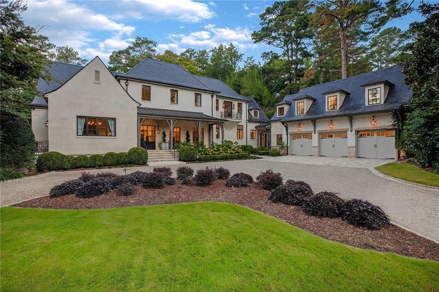 Fall in love with the craftsmanship and timeless style of this seven-bedroom, eight- and one-half bathroom Buckhead masterpiece, set amidst manicured grounds at the end of a cul-de-sac street on nearly 2+/- private acres that border the Blue Heron Nature Preserve. Boasting a carriage house/au pair suite with a separate entrance, resort-inspired grounds, a terraced garden and a poolside oasis, it is a property built for celebrating life.

No expense was spared in the construction and finishes, which include 200-year-old beams from a Belgian lock, rare European lighting fixtures, hand-chiseled French limestone floors, François & Co. mantelpieces, Bevolo gas lanterns, French oak floors, custom iron windows and doors, antique fountains from Europe and more. At the end of a wide circular drive, the manor-like facades of the main and carriage house finished with stone and stucco and Spanish slate roofs, are elegantly simple and low-maintenance. Multiple custom iron French doors beautifully merge the indoor and outdoor space along the front porch, finished with a wood ceiling.

Enter to discover a symmetrical open floor plan designed perfectly for living and entertaining. French Provincial style is reflected in the soft lines, the texture-rich interior filled with wood, iron and stone accents, plaster walls and the serene colors that reflect the surrounding landscape. Immediately, a staircase with a custom iron railing and balustrades curves dramatically to the second level in the two-story foyer, featuring a multi-level chandelier and set off by hand-chiseled French limestone floors. A light-filled home office overlooking the front courtyard, featuring exposed beams and a balcony, is tucked to the side. To the right, the formal banquet-sized dining room featuring French oak floors and 18th-century chandeliers accommodates 12+ and connects to both the fireside great room and the kitchen.

Setting the bar for casual elegance, the spacious great room with a fireplace and two seating areas opens to a mirrored wet bar and the screened porch. Just beyond the wet bar is the chef’s kitchen, as functional as it is beautiful, featuring professional-grade appliances, custom Bell cabinets, marble countertops, a pewter-topped island, a custom François & Co. hood and an adjacent walk-in pantry and home manager’s office. The fireside breakfast area opens to the well-equipped outdoor kitchen featuring a grill, a gas range and prep area and views of the pool and backyard.

A tranquil retreat featuring a gorgeous cathedral wood ceiling with exposed beams, the main-level primary suite opens through French doors to a separate patio with seating around a fireside table and boasts a spacious walk-in closet with built-ins. The marble spa-inspired en suite bathroom features a soaking tub, a double shower with built-in seating and dual vanities. In addition, there is a secondary guest suite located on the main level with a bathroom offering pool access. 

Accessed via staircases at opposite ends of the home, the second level features three additional en suite bedrooms, a living area with a built-in desk, a flex room and storage. The daylight terrace level offers room to expand while currently featuring a fireplace, a fully conditioned 1000-bottle wine room, a home gym with a full bathroom and a custom sauna with a Himalayan salt wall, a home theatre, yet another bedroom suite and more finished flex spaces. 

Through an attached breezeway is the three-car garage, and located above is a spacious, light-filled au pair suite, complete with a living area, kitchen and en suite. Outdoors, the heated saltwater pool with an attached spa is surrounded by a beautiful stone deck, and around the side is a terraced garden with raised beds edged in stone. Magazine-worthy and crafted to last, this home is a place you will never want to leave.