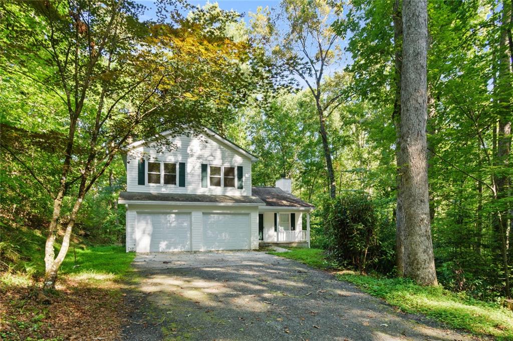 Charming traditional home on 2+ wooded acres in desirable Martins Grove—just 6 minutes from historic Dahlonega and UNG. No HOA and no rental restrictions! This open floor plan is perfect for family gatherings or entertaining, with a cozy fireplace in the great room that flows into the kitchen and dining area. Enjoy peace and privacy on the oversized deck overlooking rolling woods. Upstairs features 3 spacious bedrooms, including a primary suite with ensuite bath. A bonus main-level bedroom with private entrance offers flexible living—ideal for guests, multi-gen, or office. Freshly painted with new light fixtures and ceiling fan on main level. With close proximity to wineries, trails, and waterfalls, this home is ideal for families, students, or short-term rental income. Move-in ready—homes in this location rarely come available and won’t last long! Insane Buyer Opportunity! I’ve teamed up with Capital Mortgage Solutions to offer a 1% down loan program where the lender covers the additional 2%—up to $7,000 for qualified buyers! That means you could get into this home with just 1% down and the lender provides the rest! Call Ben Thornton at Capital Mortgage Solutions to see if you qualify!