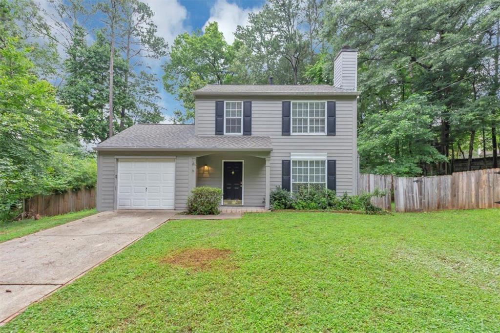 Welcome to this charming two-story home situated on a spacious quarter-acre lot. Curb appeal abounds with shrubs, exterior shutters, and a welcoming front yard. Step inside to warm wood laminate flooring that flows seamlessly throughout the home, beginning in the inviting family room featuring a cozy fireplace—perfect for relaxing evenings. The main level boasts a separate formal dining room ideal for entertaining, along with a bright eat-in kitchen outfitted with stainless steel appliances that stay with the home. A convenient powder room is also located downstairs for guests. The laundry area is tucked away in a dedicated room within the garage, maximizing space and function. Upstairs, you'll find all bedrooms, including a generous primary suite complete with a ceiling fan, tub/shower combo, and ample closet space. A white banister staircase, detailed crown moulding, and classic baseboards add elegant finishing touches throughout. Blinds on the windows and the raised panel interior doors add a refined feel. Step outside to enjoy the large backyard with a patio—ideal for outdoor dining or simply relaxing in your private space. Don’t miss the opportunity to make this well-appointed home your own!
