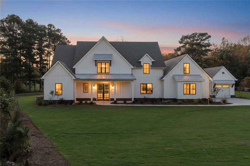 ** READY NOW ** Welcome to this stunning NEW CONSTRUCTION home, nestled on a level and private 0.92-acre lot in an exclusive enclave of just five custom homes in an A+ Woodstock location. With a striking elevation and impeccable curb appeal, this residence offers refined luxury, thoughtful design, and energy-efficient features throughout.
Step inside from the covered front porch to a vaulted family room anchored by a beautiful fireplace, featuring  custom built-in cabinets and floating shelves on each side. A spectacular 16-foot sliding glass door opens to a spacious covered rear patio with its own cozy fireplace—ideal for entertaining or quiet relaxation while overlooking the private, level backyard, perfectly suited for a future pool.
The main level features a luxurious primary suite with a spa-inspired ensuite bath, showcasing a zero-entry shower, designer tile, quartz countertops, and dual custom walk-in closets. A separate guest suite with its own zero-entry bath, a large laundry room, and a well-designed mudroom add everyday convenience.
The gourmet kitchen is a showstopper with an oversized island, quartz countertops, a slide-in range, abundant cabinetry, and a separate dining or breakfast room for effortless entertaining. A stunning switchback staircase leads to the second floor, where you'll find two spacious bedrooms, each with its own ensuite bath, and a versatile bonus room perfect for a den, office, or playroom.
Built with comfort and efficiency in mind, this home includes spray foam insulation, a tankless water heater, high-efficiency HVAC, and low-maintenance vinyl windows. Every corner reflects quality craftsmanship and luxurious detail—this is Woodstock living at its finest.