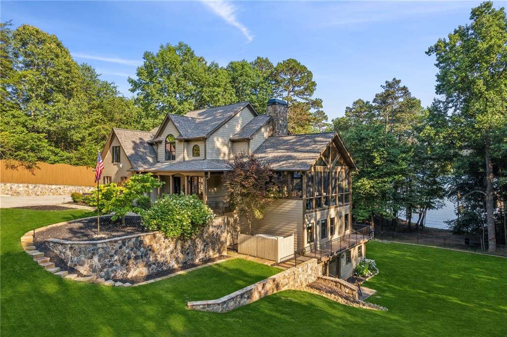 Set on a rare double lot with 1,100 feet of shoreline, this property is a true lakefront sanctuary. Outdoor living takes center stage with two private, rebuilt deep-water docks, a boathouse with 9,000-lb lift, dual jet ski ports, party deck with SunShade, and even a private beach. The grounds are meticulously landscaped with dramatic lighting, a cascading water feature, and a family-sized fire pit—perfectly illuminated from dusk to dawn. Inside, the home offers 5 bedrooms plus an office that can double as a 6th bedroom, a spacious fireside screened porch, and a terrace-level “man cave.” Extensive recent upgrades include a new roof with spray foam insulation, new HVAC systems and duct work, a Generac Quiet whole-home generator, EV charging station, tankless water heater, a comprehensive irrigation and drainage system, and more. Whether entertaining on the water, gathering around the fire pit, or relaxing on the screened porch, this property delivers the ultimate Lake Lanier lifestyle—privately gated and designed for year-round enjoyment. And for those seeking an investment property, this home has a proven rental history with records available, making it an exceptional opportunity on one of Georgia’s most desirable lakes.