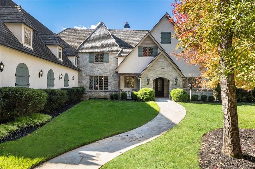 Storybook Country French Manor on Two Acres

Welcome to this custom-built Country French manor, completed in 2018 and offered for the first time to market. Perfectly positioned on two private acres just a stone’s throw outside of Milton, this timeless residence is one of only five homes on the lake—offering both privacy and prestige in an unmatched setting. Scottsdale Farms, Seven Acre, and Baby Barn Publix are just minutes away, with Crabapple within 15 minutes, and Alpharetta, Avalon, and GA-400 accessible within 25 minutes.

The exterior captivates with hand-chiseled stone, stucco, and shake siding, a handcrafted shake roof, and gas lanterns flanking the front entry. The covered and screened rear porch features a built-in grill and a gas line ready for a fire pit, providing a serene space to relax while enjoying views of the surrounding landscape and lake. A 20-zone irrigation system ensures every inch of the lush property remains beautifully maintained.

Inside, custom Anderson casement windows fill the home with natural light, while Elm hardwood floors, slate stone in the foyer, and timeless architectural details lend warmth and authenticity throughout. The Great Room’s ceiling is crafted from Pecky Cypress, adding texture and distinction. Two wood-burning fireplaces with gas starters—one in the Great Room and one in the Den—create inviting spaces for gathering.

The main level offers four en-suite bedrooms, including two luxurious primary suites, each with spa-style baths. The primary bedroom features reclaimed beams sourced from a historic barn in West Virginia. A private study with a secondary workspace nook provides the perfect retreat for reading or productivity.

At the heart of the home, the chef’s kitchen showcases stained walnut cabinetry and top-of-the-line Wolf, Sub-Zero, and Miele appliances, including a built-in microwave and wine refrigerator in the oversized pantry. Just off the kitchen, a craft room adds flexibility—ideal for creative projects or extra storage. A spacious laundry room with sink completes the main level’s thoughtful design.

The lower level expands the home’s versatility, featuring a fully equipped gym with rubberized flooring, a finished storage room, and a professional woodworking shop designed with comfort and function in mind. The shop includes a full dust collection system at every workstation and a raised plywood panel floor—known as a DryCore subfloor—created to provide anti-fatigue support underfoot. This thoughtful detail ensures hours of comfort while working and also serves as an ideal subfloor should you wish to install hardwoods over the concrete in the future.

Car enthusiasts will be delighted by the automotive amenities—an oversized 3-car garage on the main level (30’ deep), plus a 4-car terrace-level garage designed to accommodate up to eight vehicles with lifts. Two lifts—one four-post and one two-post—are already in place. A convenient parking pad allows two additional cars to park without blocking the driveway.

Built with comfort and accessibility in mind, the home includes spray foam insulation throughout, an elevator, and ADA-compliant wide doorways for seamless mobility.

This one-of-a-kind residence combines craftsmanship, comfort, and character in every detail—a true storybook dream brought to life.