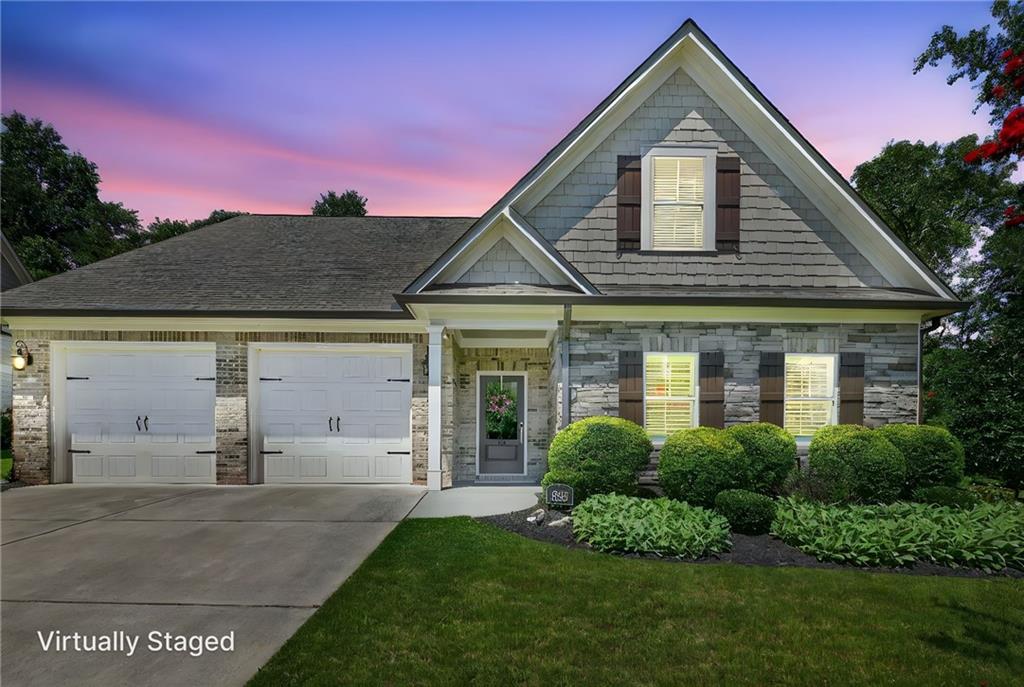 Fantastic Value -approx. $259/sq ft! Comparable homes in the area @ $270-$280/ sq ft. This home looks barely lived in! Beautiful and full of designer finishes. Walking distance to Cumming City Center w/ shopping, restaurants and entertainment! Gated 55+ community, private "end" home w/ heavily wooded views to the back and right side of the home! Custom trim, coffered ceilings, upgraded lighting, Butler's pantry, separate Walkin pantry, formal Dining Room, gourmet kitchen w/ granite counter-tops, wine fridge, double ovens and large island open to the Family room. Main level primary suite w/ beautiful bathroom, frameless over-sized shower, double vanities and fantastic Walkin closet! Large laundry room w/ "barn door" and work sink! Second private suite on the main level w/ private bath and away from the rest of the living space. 3rd private bedroom suite upstairs w/ separate sitting room, private bath and direct, walk in access the tremendous attic storage area. Oversized garage w/ Epoxy floor covering. But wait until you see the amazing screened-in porch overlooking the private, landscaped backyard with stone patio and wrought iron fencing! You'll spend hours in this wonderful space throughout the year, relaxing with a good book or watching your favorite football team all season long... The community has a beautiful pool and clubhouse that are steps away from your front door, with a pickleball Court and fitness center. Yard maintenance is included in the monthly association fee and there is nothing else like this on the market! Don't wait or this amazing home will be gone!!