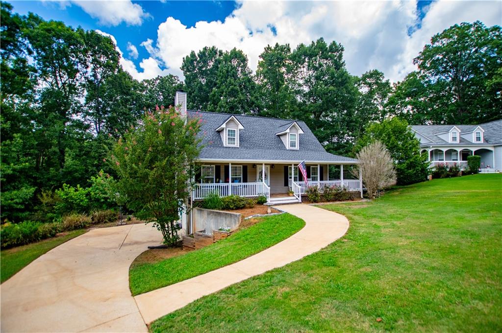 Charming and Immaculate Home with Inviting Wrap-around Porch! This beautifully maintained home exudes charm and comfort, starting with a welcoming wraparound rocking chair front porch-perfect for relaxing or entertaining. Inside, you'll find a light-filled open family room featuring a stacked stone fireplace. The main-level primary suite provides private access to the covered porch and includes a spacious en-suite bath with dual vanities, a separate tub and shower, and ample closet space. Additional highlights include a half bath, a large laundry room, and generously sized guest bedrooms upstairs, each with large closets! The full basement includes a two-car garage, abundant storage, and a finished bonus room-perfect for a home office, gym, or media space (Currently being used as a home gym!) This home is situated perfectly on a quiet cul-de-sac lot, is in excellent condition, and ready for its next chapter. Also, includes a brand NEW back deck!! *** Seller offering a $3,000 carpet allowance with acceptable offer!*** ALSO, the roof is only 6 years old and the HVAC was fully replaced 2-3 years ago!