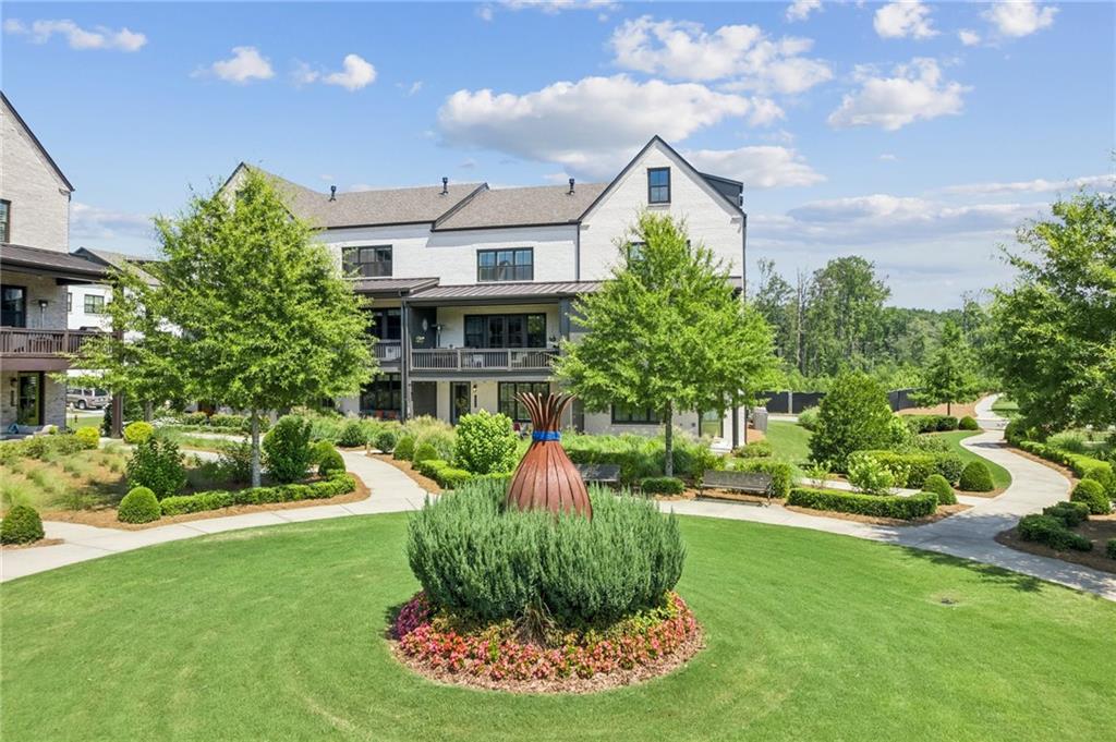 Experience Unmatched Views and Luxury Living in the Heart of Halcyon
Experience the Halcyon lifestyle on one of the most coveted lots in the highly desirable Garden District of Halcyon in Alpharetta, GA. This exceptional home offers truly one of the BEST views overlooking beautifully landscaped green space with unobstructed views to Halcyon’s vibrant shopping, dining, and entertainment district, the Big Creek Greenway, and beyond. And the sunsets? Absolutely spectacular! Unwind on your covered back porch or patio, where comfort meets calm. Surrounded by nature and subtle luxury, it's the perfect place to relax and enjoy the peaceful simplicity of home.
This exceptional home showcases the sought-after Harleigh floor plan, the largest townhome model in the community offering a light-filled, open-concept layout with soaring 10' ceilings on main, plantation shutters, and a seamless blend of elegant design and everyday functionality across all three levels. Featuring four spacious bedrooms and 3.5 bathrooms, this elevator-ready home was built with premium upgrades and is perfectly positioned just steps from the heart of Halcyon.
The expansive, welcoming front porch offers serene views of the lush greenspace, creating a perfect spot for outdoor relaxation and connection. Step into the inviting foyer, where you will find a versatile bedroom, home office, or flex space that is paired with a full tiled bath. Just beyond, the two-car garage offers sleek epoxy floors and a convenient side entry door for added functionality.
The main level highlights a light-filled, open-concept design centered around a gourmet chef’s kitchen, complete with premium stainless-steel appliances, an expansive island with bar seating, and a generously proportioned dining area, an ideal setting for elegant entertaining. The adjoining family room, anchored by a charming gas fireplace, seamlessly extends to a spacious covered deck through classic French doors, offering an inviting space to host guests or unwind amidst stunning panoramic views. A remote-controlled shade enhances both comfort and convenience.
Upstairs, the primary suite offers a relaxing retreat with a tray ceiling, spa-like bath with dual vanities, and a frameless tiled shower. Two additional secondary bedrooms share a well-appointed full bath, and a hallway laundry area completes the upper floor.
Community amenities include a pool, clubhouse, large courtyard, expansive green spaces, and direct access to the Big Creek Greenway. Zoned for top-rated Forsyth County schools with easy access to GA-400 and surrounded by exciting new developments—including the proposed and highly anticipated "The Gathering", this area is quickly becoming one of the most sought-after destinations north of Atlanta.
Don’t miss this rare opportunity to live in luxury, surrounded by nature and just steps from the best of Halcyon. Schedule your private tour and see why this home offers more than just a place to live, it’s where everyday living feels extraordinary.
