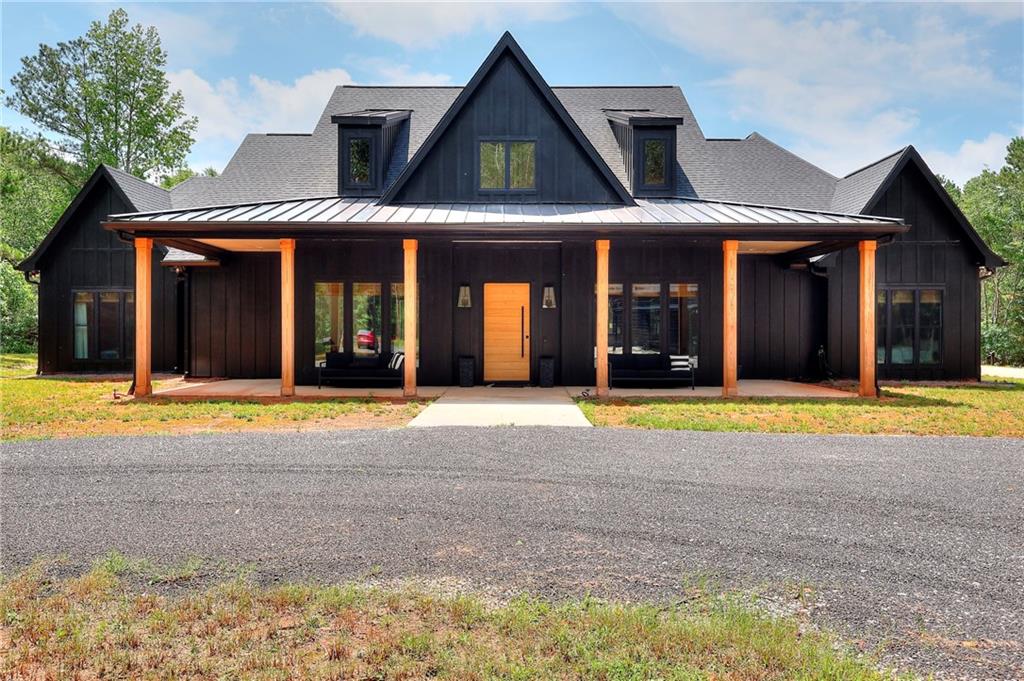 Where Luxury Meets Land: A Private oasis just minutes from it all tucked away on a quiet street this 11.21-acre estate offers the rare blend of total privacy and unmatched convenience all while being centrally located to downtown Monroe, Loganville, Barrow Crossing, and the new YMCA. This custom-built home was designed for those who crave space, style, and smart living. Offering over 3,800 sq ft this home is packed with thoughtful upgrades and warm, modern finishes. From the moment you step through the solid white oak pivot front door into the 20-foot, two-story foyer, you are met with an open-concept design while showcasing your lush backyard through a 16 x 8 ft sliding glass door. At the heart of the home, a 10-foot quartz island anchors the kitchen, outfitted with a gas range, champagne bronze accents, and a moody walk-in pantry featuring custom bookcase-style shelving, a dry bar, and a built-in mini fridge. The living room's venetian plaster gas fireplace adds a cozy focal point, while the adjacent outdoor wood-burning fireplace (with gas starter) creates the perfect setting for cool evenings under the stars. The primary suite is a retreat of its own, with a spa-style bathroom, dual vanities, and direct access to the laundry room that is complete with quartz counters and ample storage. Two additional bedrooms share a jack-and-jill bath, while a fourth has its own ensuite. Upstairs, a versatile bonus room features a full bath, closet, mini-split, and a wall of custom cabinetry making it perfect for an oversized fifth bedroom, a home office, media room, or flex space. Modern living is easy here: enjoy instant, endless hot water with a recirculating tankless system, climate control through Nest thermostats and dual HVAC units, spray foam insulation throughout, and ethernet hardwiring to all TV locations for fast, seamless streaming. The climate controlled 3-car garage and oversized attic storage with stair access add even more functionality. Outside, you'll find a grand, vaulted ceiling perfectly highlighting the mature oak trees. A custom outdoor kitchen with a 7-foot island, two mini fridges, a built-in Blackstone, and a Bullseye pellet grill that is ready to host everything from Georgia game day BBQs to quiet summer nights with friends or family. Also included with this showstopping property is a 2,100 sq ft metal shop with spray foam insulation, two 9-foot fans, a lean-to for equipment, and endless potential for when you need extra space for work, hobbies, or just weekend toys - this is it! This private property offers a custom gated drive with keypad, cellular video, and audio service. Ensuring easy access in all seasons, the asphalt milling driveway completes this picturesque property. If you're looking for a home that feels like a retreat but lives like a modern masterpiece, this is the one.