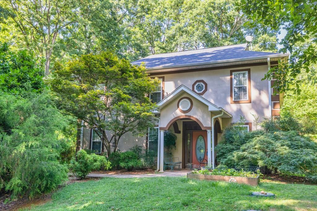 Charming Home on Private, Wooded Oasis of a Property with Neighborhood Lake Access! You won't find another gem like this! Spacious 2-Story Family Room with natural light pouring in through floor-to-ceiling windows (with electric blinds). Classic Kitchen features beautiful birch cabinetry, granite countertops, rustic backsplash, and island with seating. Pantry and Butler's Pantry for storage. Separate Dining Room and Formal Living/Office/Sitting Room. Upstairs, the spacious Owner's Suite is sure to impress with an ensuite Bathroom featuring a Wet Room with dual shower heads, double vanities, and a walk-in closet. Two additional Secondary Bedrooms share Full Bathroom. Upstairs Laundry & access to beautiful views from the Balcony. Basement is accessible from outside and is the perfect storage/workshop space. The backyard is your own private oasis: large patio space with modern railing, electrical run for a hot tub, stone walkway, and lower paver patio area overlooking the waterfall feature with fish pond! Surrounded by trees, yet a stone's throw from the lake and access via neighborhood's boat ramp.