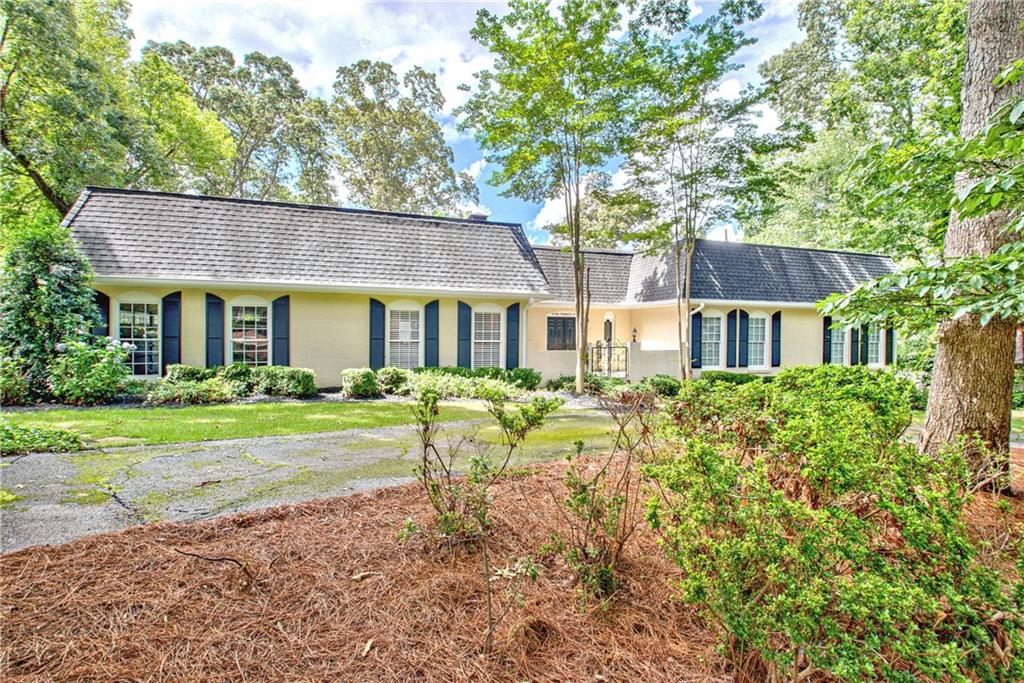 This classic brick ranch with a pool and an amazing view of Flat Creek's Homestead golf course offers the rare opportunity to enjoy mid-century elegance and modern comfort! From the moment you approach the formal entry court, with its circular drive, wrought iron gate, natural flagstone, fountain, and elegantly inscribed with "Five Twenty-Two" above the double front doors, you'll sense the thoughtful design and enduring charm that define this beautiful, completely updated home. Inside, a lovely foyer welcomes you through to a large living room with French doors that open to a vaulted sunroom with warm wood-paneled ceilings, expansive windows, and abundant natural light, overlooking a large new deck, and the fenced back yard sanctuary with its lush, attractive landscaping, a beautifully maintained heated pool, a large terrace level patio with a hot tub, a storage shed, and another delightful outbuilding offering potential as a studio, pool house, or gardening shed. Back inside, the kitchen blends form and function with quartz countertops, stainless steel appliances, a large elegant island, abundant cabinetry and countertops, and designer backsplash and lighting. In the primary suite, the spa-like primary bathroom features a freestanding clawfoot tub, walk-in shower, elegant marble accents, and herringbone flooring, offering both luxury and tranquility. Downstairs on the lower level you will find a large recreation/ living room with built-ins and a fireplace, along with a beautiful bedroom and full bath, the large laundry room, a bonus area perfect for a gym, playroom, quiet office, home theater, or additional living space, and a workshop/storage area ideal for tools and hobbies. Set within the quiet, well-established neighborhood of Golfview, and just minutes from shopping, dining, great schools, and parks, and easy access to the Atlanta airport, 522 Golfview Drive has everything you're looking for, and more!