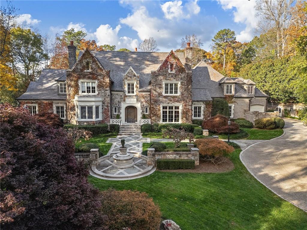 Set on an expansive three-acre private estate in Atlanta's exclusive Paces Ferry neighborhood in Buckhead, this stunning custom stone English manor, designed by renowned architect William T. Baker and built by custom builder McGarity.Timeless elegance combined with modern sophistication. Exceptional value at this price and available now. This gated property set way back from the street with a sweeping drive leading to a meticulously designed motor court and four-car garage, ensuring plenty of parking options. The interiors finishes are a testament to exceptional craftsmanship, beginning with the grand two-story foyer, where oak paneling and marble floors set a luxurious tone. To the left, an elegant study with fireplace provides a refined retreat. To the right, is a formal living room with fireplace or seating area. The heart of the home is the chefs kitchen and separate catering prep kitchen. Featuring two expansive islands clad in marble, professional-grade appliances, and dual pantries - including a butlers pantry - designed to make entertaining seamless. This space flows effortlessly into the spacious family room, complete with soaring vaulted ceilings, a cozy fireplace, and an adjacent sunroom that invites natural light and views of the lush surroundings. A standout feature is the glass conservatory, imported from England, offering a serene space to enjoy the gardens year-round. The main-level primary suite is a private sanctuary, complete with a sitting area, fireplace and overlooking the pool.  Two separate generously sized dressing rooms. Upstairs, four additional bedrooms, each with en suite bathrooms, provide ample accommodations for family and guests. A versatile bonus room and an elevator that accesses all three levels add to the homes functionality. Whole house generator, upgraded integrated lighting and security system. The terrace level is designed for recreation and relaxation, boasting a billiards area, full bar, wine cellar, fitness center, sauna, and a state-of-the-art movie theater. Outside, the grounds, envisioned by famed landscape architect John Howard, offer a resort-like experience. Enjoy lush, professionally curated gardens with over 70 specimen Japanese Maples, a sparkling pool with a hot tub, an open-air summer pavilion, and a dedicated play area with playhouse.  This 3 acre estate offers unparalleled access to Buckhead premier shopping, dining, and some of the cities top public and private schools. Own  a legacy property blending classic sophistication with modern amenities in one of Atlanta's most sought-after locations.