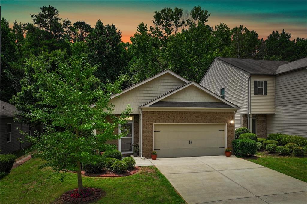 Brick and siding exterior with an attached garage and concrete driveway