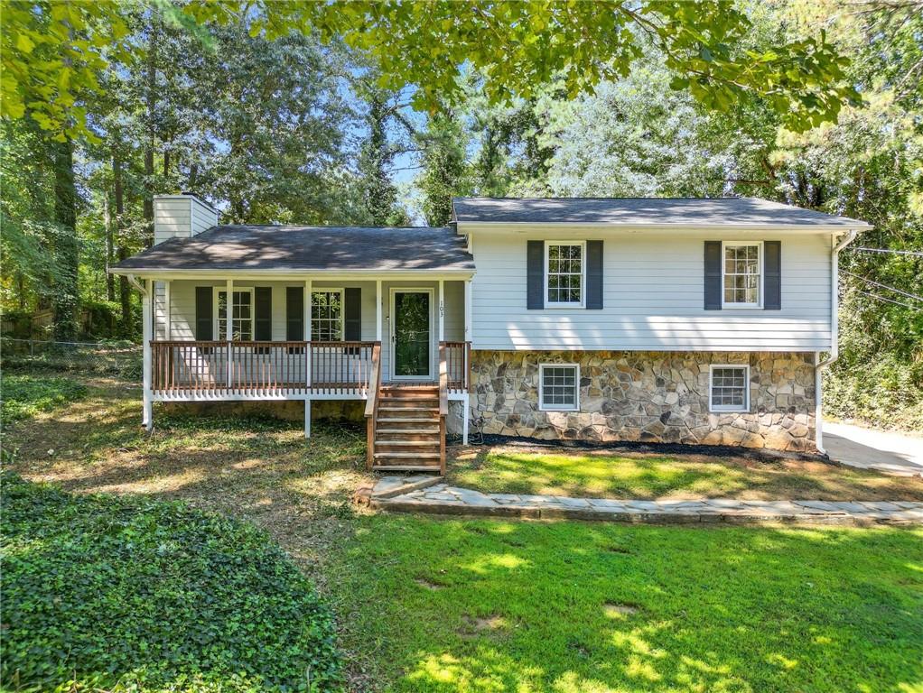 Fantastic split-level home in Woodstock. This 3 bed, 2 bath property features a large open living space and a kitchen with white cabinets and stainless steel appliances on the main floor. Upstairs you will find the primary suite along with two additional bedrooms and a full bath. The lower level offers utilities, storage space, and a two-car garage. Additional highlights include a covered front porch, rear deck, and a spacious backyard. The home is walkable to Carmel Elementary and offers close proximity to both I-75 and I-575.