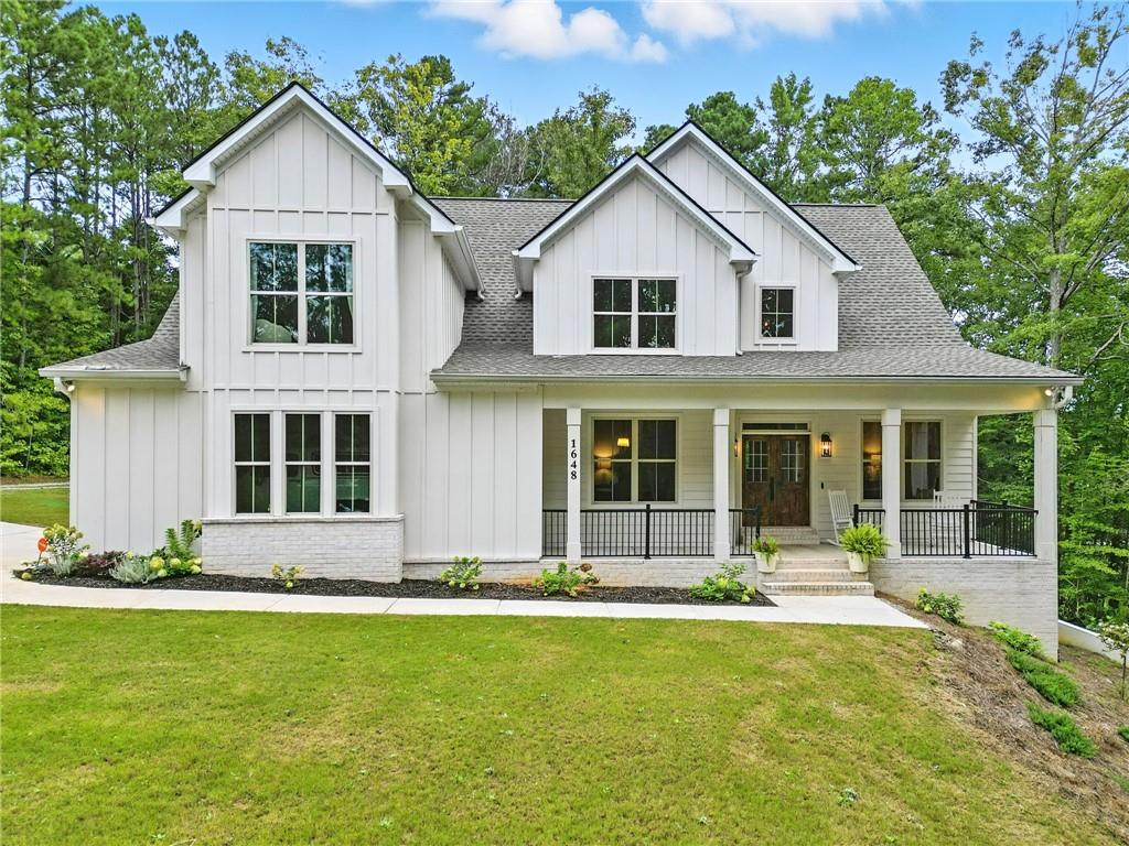 Welcome to your dream modern farmhouse retreat! Nestled on a serene 1 acre lot, this stunning 4 bedroom, 3.5 bath, full walkout basement home blends sophisticated elegance and cozy old world charm throughout. Built in 2022, this 3,066 sf residence boasts an open concept layout with designer qualities and flair, clean lines, warm tones, arched doorways, soaring ceilings, executive level trim, hardwood laminates on the main level, and abundant natural light streaming throughout. The heart of the home is the bright and airy kitchen with a fresh and timeless appeal featuring a sprawling 9 ft. quartz island, ample custom shaker soft close cabinetry, stainless steel appliances including a double oven, decorative shelving and hood vent, farmhouse sink, and large walk-in pantry. Just near is the breakfast nook overlooking a tranquil backyard set amidst lush Georgia hard woods and pines. Adjacent, the large living area centers around a custom cast stone Euro decorative fireplace, high peaked ceilings, and a wall of rear facing windows framing a gently sloping backyard. The main floor primary suite is roomy and offers a spa-inspired bathroom with a freestanding soaking tub, dual vanities with upgraded faucets, an arched walk-in rain shower, walk-in closet, plus convenient direct outdoor access via a sizable covered porch- an inviting spot for morning coffee or reading time. The main floor also features a welcoming double door entryway, double French doors leading to flex space ideal for an office or den, a spacious and inviting formal dining room, a half bath, decorative hall alcove with storage, and laundry room with wash basin. Upstairs and providing ample room for family or guests, are three spacious bedrooms with wall accents adding a pop of style, two full baths, and a versatile bonus room ideal for a play area or media space. Outside, the private backyard includes a large covered porch, play structure for children, and plenty of space for a pool. Throughout this lovely home, you’ll find carefully chosen upgraded lighting fixtures that blend style and function, elevating every space. Additional highlights include alarm system, and prewiring for intercom. This modern farmhouse is more than a home- it’s a lifestyle. While offering the ultimate secluded setting, it’s surrounded by top-rated schools, restaurants, shopping, parks, walking trails, a local library, and vibrant community events. This serene retreat offers the perfect balance of rural charm and modern convenience. Schedule your visit today!