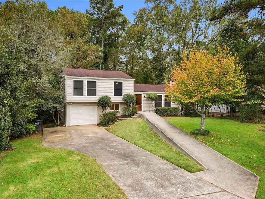 Welcome to this fully renovated 4 bedroom, 3 bath, split level home where modern design meets everyday comfort! Fresh exterior paint, manicured landscaping, and an inviting entry lead to a bright and open concept interior with soaring ceilings and a striking floor to ceiling brick fireplace. The stunning kitchen impresses with white cabinetry, quartz counters, subway tile backsplash, stainless appliances, and a large island complete with bar seating. The main level primary suite offers walls of windows, a spa like ensuite, and serene backyard views. Upstairs are three spacious bedrooms and two beautifully updated baths, while the finished basement provides flexible bonus rooms, ample storage, and a one car garage. Enjoy outdoor living on the brand new deck overlooking a peaceful, wooded yard. With new paint, flooring, lighting, and fixtures throughout, this home feels brand new, perfectly blending style, comfort, and convenience near many shopping and dining options!