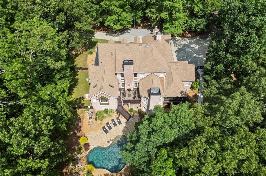 Welcome to Bent Tree Estate, an elegant and private retreat set on nearly 8.5 acres in a quiet gated enclave—where luxury, comfort, and nature come together in perfect balance. This four-sided brick estate includes a stunning main residence with over 8,900 sq. ft. of refined living space and a separate 1,000+ sq. ft. guest house, ideal for extended family, guests, or rental income. Designed for both grand entertaining and everyday ease, the main home offers 6 bedrooms, 5 full and 2 half baths, and three finished levels of thoughtfully designed spaces. The main level features a spacious primary suite with a spa-inspired bath and dual walk-in closets, a welcoming guest suite, and a beautifully renovated chef’s kitchen with premium appliances, custom cabinetry, and a large island for gathering. Throughout the home, five fireplaces, rich hardwood floors, and custom finishes create warmth and timeless appeal. Upstairs, three well-sized bedrooms include an en-suite and Jack-and-Jill bath, while the terrace level offers the ultimate leisure retreat—complete with game room, kitchenette, sauna, full bedroom suite, and direct access to the heated Pebble Tec saltwater pool. Enjoy year-round outdoor living with a wraparound front porch, screened porch, and patio overlooking the pool and wooded backdrop—perfect for peaceful mornings or lively gatherings. Additional highlights include a whole-house generator, detached two-car garage with EV charging station and loft storage, plus a total of five garage spaces between both homes. The guest house currently generates $1,575/month in rental income through February 2026, offering built-in value and flexibility. Tucked along a private, tree-lined road shared with a handful of neighbors, Bent Tree Estate provides the rare combination of serenity and convenience—just minutes from GA-400 and the North Georgia Premium Outlets. Experience the best of North Georgia living in a setting that feels worlds away.