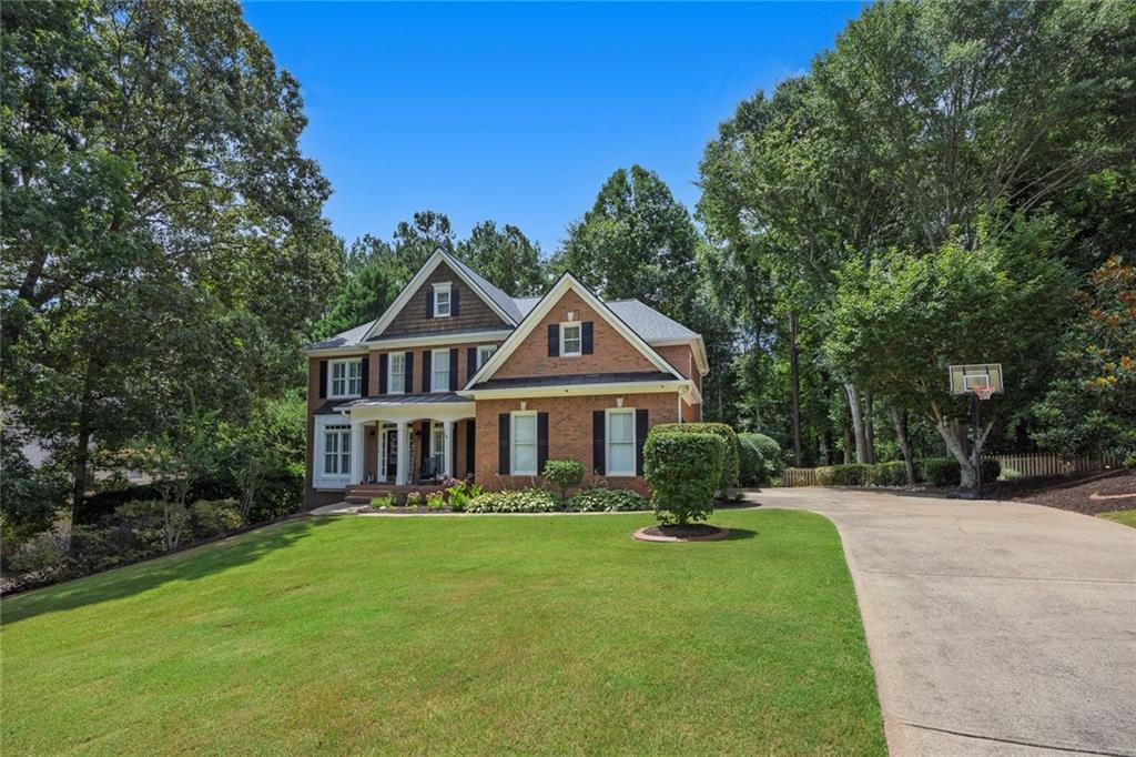 Welcome home to 109 Fairway Overlook, a stunning 3 sided brick home in the much sought after Bradshaw Farm Golf Community. Featuring 5 bedrooms, 4.5 baths, with a full finished basement, this home has lots of space, and plenty of updates. Walk into the 2 story foyer and you are met with fresh new paint throughout the main level. To the right is a spacious dining room and large office to the left, both with executive crown molding, highlighting the custom craftsmanship this home has to offer. The expansive 2 story living room features a fireplace & wall of windows that floods the space with lots of natural light. The open concept layout seamlessly connects the chefs kitchen featuring granite countertops, island and custom cabinetry. Hardwoods throughout, a half bath and custom built ins framing the fireplace finish off the main level. Upstairs you will find 4 bedrooms, and 3 full baths with new flooring and paint throughout. The primary bedroom features a beautiful tray ceiling, with generous space for a king size bed & sitting area, with a private en suite bath and spacious walk in closet. Walk down to the basement, which is an entertainer's dream. Finished with a built in bar, a second fireplace for added ambiance, a private home office, full bathroom and a dedicated space for a gym. Whether you are working from home, hosting, or recharging, this space offers unlimited flexibility. Enjoy the newly painted deck overlooking the large flat backyard, complete with a relaxing hot tub, perfect for unwinding after a long day. Every feature of this home has been thoughtfully designed with a perfect balance of comfort & style. The community features a 27 hole golf course with bluetooth enabled Yamaha Golf Carts, 2 pools, junior Olympic Sized pool, clubhouse, basketball and volleyball court, walking trails, multiple tennis courts and playground. This home and community have everything- all that's missing is you!