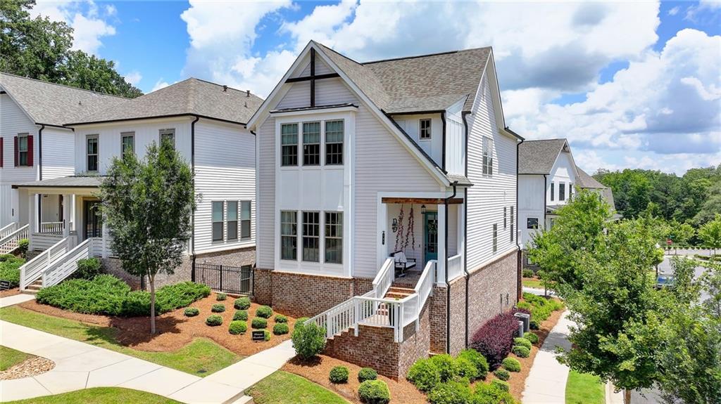 Enjoy Suwanee Old Town Living in this beautiful craftsman/farmhouse style home. Corner lot with lots of street parking for your quests. Rocking chair front porch. Enter into the open-concept main level including living room and dining area. Chef's kitchen includes a large island with seating for six, quartz countertops, white cabinets with stainless steel appliances. Hardwood floors throughout entire home. There is a large back porch on the main level overlooking the community. Upstairs is the luxury primary suite with double vanity and huge custom walk-in shower. Also on upper level are two additional bedrooms and a full bath. The terrace level features a guest suite with full bath and additional living space. Home includes closets where an elevator could be installed. EV Charger in garage. HOA maintains the yard. Community includes a cabana, pool, and fire pit. Walk to greenways, community garden, Suwanee Town Center with restaurants, shops and events almost every weekend!