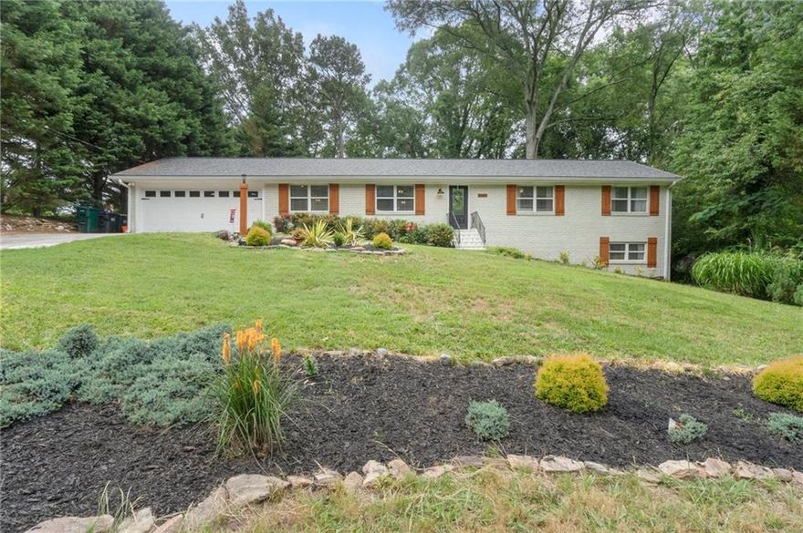 This charming white three-sided brick ranch offers a spacious and thoughtfully updated interior with unbeatable convenience to interstates, shopping, dining, parks, and top-rated schools. The beautifully landscaped yard and fenced, private backyard provide a peaceful retreat, complete with a large deck perfect for entertaining. Inside, the open floor plan features a beamed ceiling in the great room, abundant natural light, and a cozy gas white brick fireplace with wood storage and mantel. The kitchen is a chef’s dream with white cabinetry, pantry, granite countertops, stainless steel appliances, a gas cooktop, granite countertops, bar/island, and recessed lighting that continues into the dining area. Hardwood floors flow throughout the main level, while the updated primary bathroom showcases stylish subway tile and shiplap accents. The finished basement includes a versatile game room/playroom, a fourth bedroom, and an unfinished area ideal for storage. Additional highlights include tile floors in bathrooms, ceiling fans, a two-car garage, and a separate storage building. This home blends comfort, style, and function in sought after East Cobb.