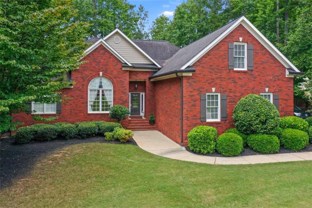 Tucked away on a quiet cul-de-sac in the sought-after Lakehaven subdivision, this extremely well-maintained 4 bedroom, 3.5 bath, brick home blends timeless elegance with exceptional livability. Lakehaven residents enjoy premier amenities including two sparkling community pools, tennis courts, and access to the highly regarded Union Grove school district. From the moment you arrive, the home's pristine condition and grand presence are undeniable. Inside, gleaming hardwood floors flow throughout the wide-open floorplan, setting the stage for gracious living and effortless entertaining. The attached two-car garage, complete with finished flooring, adds both function and style. The true showstopper is the incredible outdoor living space-a partially covered and partially open back deck with a built-in fireplace, gated enclosure, and cobblestone patio-ideal for everything from cozy evenings to lively gatherings. Step through the impressive foyer and find the formal dining room to your left, seamlessly connecting to the oversized family room with soaring vaulted ceilings, a warm fireplace, and direct deck access. The chef's kitchen overlooks the family room and boasts stainless steel appliances, granite countertops, abundant cabinetry, a breakfast bar, and a sunny breakfast area. The main-level primary suite is a private retreat with tray ceilings, an expansive walk-in closet, and a luxurious en suite bath featuring double vanities, a stand-alone soaking tub, a walk-in tiled shower, and built-in cabinetry. Two additional bedrooms and a full bath share the main level, along with a convenient powder room and laundry closet. Upstairs, the spacious bonus room serves as the fourth bedroom, complete with its own closet and full bath-perfect for an in-law suite, private guest quarters, or flexible living space. This home is the perfect combination of grand style, meticulous care, and unbeatable amenities-ready to welcome its next owner.