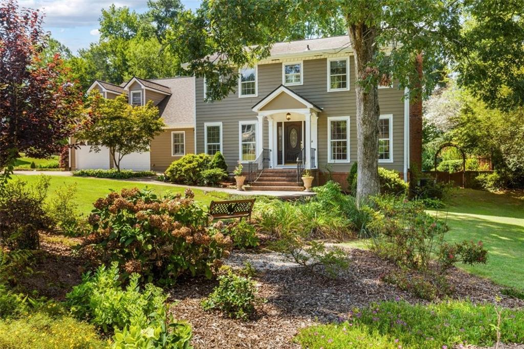 Welcome to this beautifully expanded and meticulously maintained home offering 5 bedrooms, 4.5 bathrooms, and over 4,300 square feet of living space on a private, fenced ½-acre lot. Located in one of East Cobb’s most sought-after school districts—Murdock, Dodgen and Pope High—this home is much larger than it appears from the street. The main level features a full guest suite with bedroom and bath, an office, formal dining room, den with marble fireplace and oak trim, a large living room, and an expansive gourmet kitchen with custom cherry cabinetry, center island, porcelain floors, breakfast bar, pantry, oven, microwave, warming drawer and gorgeous views of the lush backyard. The kitchen opens into a bright breakfast room and a beautiful sunroom/playroom—perfect for relaxing or entertaining. A major addition provides even more space, including a second pantry, spacious laundry room with sink and cabinets, and an extra-large bonus room accessed via rear stairs—ideal as a playroom, home gym, or media room. Throughout the main living areas, you’ll find hardwood and tile flooring, with carpet only in the bonus room. The garage is thoughtfully upgraded with epoxy floors, insulated doors, a small workshop area, and a side room for garden storage. Outside, enjoy a professionally landscaped backyard filled with flowering bushes and a large stone patio featuring built-in seating, landscape lighting, and a chef-grade built-in gas grill. Additional highlights include an updated primary bathroom with separate tub and shower, double vanities, and a large walk-in closet, two HVAC systems for comfort and efficiency, a 50-year architectural shingle roof with gutter toppers, front and rear staircases, walk-in closets, cedar closets, and abundant storage throughout. This is a rare opportunity to own a spacious and truly custom home in East Cobb. With room to spread out, high-end finishes, and an unbeatable location, this home is a must-see.