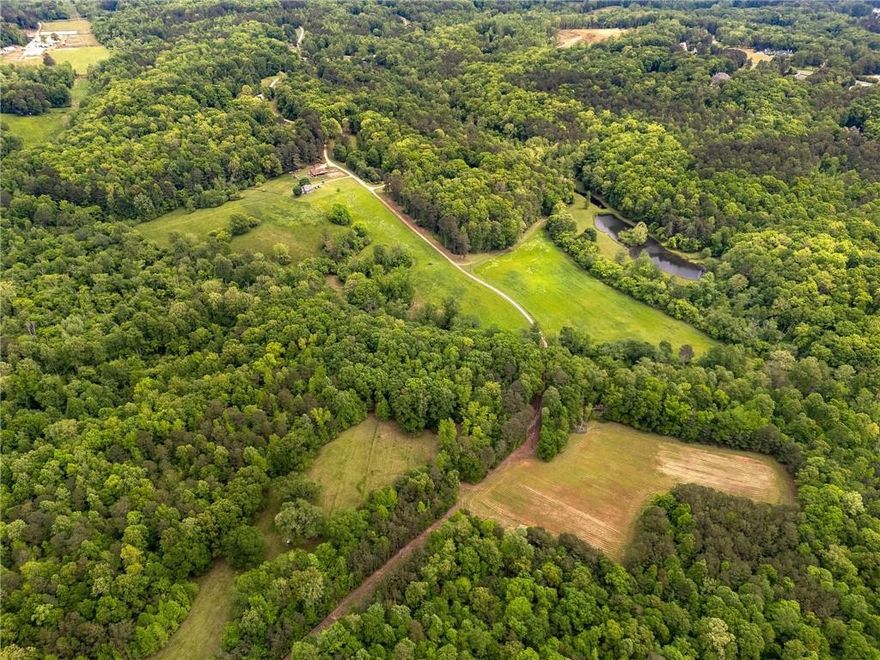 A once-in-a-generation opportunity exists to acquire one of the largest private estates in North Fulton County. This 284-acre property spans 171 acres in the City of Milton and 113 acres in unincorporated Cherokee County. The land has been owned by the same family for over 50 years and offers an unmatched combination of scale, privacy, and natural beauty.

Set behind a gated entrance, the property is a mix of rolling pastures, forests, and scenic water features. Little River runs through the property, and three picturesque ponds offer serene views and recreational potential. The estate includes three single-family residences: a 4,000-square-foot main home built in 1990 with 3 bedrooms and 3.5 bathrooms, a charming guest cabin perched on a high point of the property, and a caretaker’s residence. Additional improvements include a barn and tennis court.

The estate offers a unique blend of privacy and convenience, as it is less than an hour from Buckhead and just six minutes to the nearest Publix, with easy access to both Milton and East Cherokee’s top schools, shopping, and dining.

This is a rare legacy offering for a discerning buyer seeking a premier family compound or personal retreat in the heart of Georgia horse country.