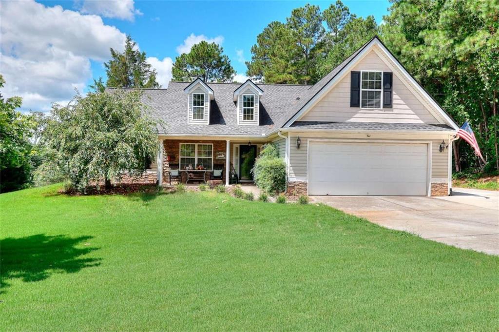 Charming Ranch on Over Half an Acre in Walton County - Bonus Room + Recent Upgrades! Welcome home to a beautifully maintained 3-bedroom, 2-bath ranch with a spacious bonus room, nestled on a quiet street in the sought-after Walnut Grove High School district. This inviting home offers 1,857 square feet of comfortable living space and sits on a generous 0.6-acre lot featuring mature trees and great curb appeal. Step inside to find an open-concept layout with vaulted ceilings and rich hardwood floors in the main living area. The kitchen features brand-new stainless steel appliances, a breakfast nook, and a view to the cozy family room, perfect for everyday living or entertaining. The formal dining room is ideal for hosting special gatherings along with the outdoor patio. The primary suite offers a peaceful retreat with a large soaking tub, separate shower, and double vanity. Two additional bedrooms and a full guest bath are located on the main floor, with a spacious bonus room upstairs that can flex as a 4th bedroom, home office, or media room. This home is move-in ready with a 3-year-old roof, newly installed septic lines, and thoughtful updates throughout. Enjoy peaceful mornings on the rocking chair front porch or host summer BBQs in the large backyard. Located in the desirable Ashley Falls subdivision, just minutes from Walnut Grove, Loganville, and Monroe shopping and dining.