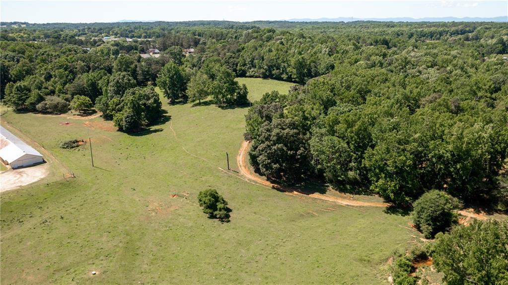IT'S ALL ABOUT THE LAND! Discover 23 breathtaking acres in the heart of North Forsyth—an exceptional opportunity to craft your dream estate, multi-generational compound, or private agricultural haven. This scenic property offers gently rolling pastureland, a picturesque year-round creek, and a scattering of mature hardwoods that create a serene natural backdrop. A driveway is already in place, with all utilities onsite, making it ready for immediate development or personal use. The land includes two 40x400 buildings, a 60x45 structure with soaring 2–3 story ceilings perfect to enclose for a shop, and an additional small shed/storage building, offering both flexibility and function. Whether you're looking to build a luxury home, raise animals, or invest in a minor platted community, this parcel checks every box. Located in one of Forsyth County’s most desirable areas, you’ll enjoy easy access to top-rated schools, scenic parks, and Lake Lanier, all while being just minutes from shopping, dining, and major highways. For outdoor enthusiasts, the proximity to the North Georgia Mountains, Amicalola Falls, and a nearby animal preserve means adventure is always at your doorstep. This rare offering blends location, infrastructure, and natural beauty to deliver the lifestyle—and land—you’ve been dreaming of.