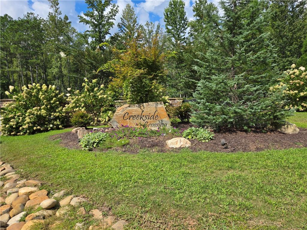 Beautiful Corner Lot in Creekside Crossing Subdivision Gilmer County. Creekside Crossing, one of Gilmer County’s newest and most desirable communities! This stunning corner lot offers the perfect blend of convenience, natural beauty, and community amenities. Located just off Hwy 136, you’ll enjoy paved roads throughout the subdivision along with access to a gorgeous clubhouse and an infinity pool overlooking majestic mountain views. The neighborhood also features a creekside park with picnic pavilion and fire pits, plus nature preserves with hiking trails that lead to serene creekside areas. Perfectly situated, you’ll be only minutes from Ellijay, Jasper, and Chatsworth and just 5 minutes to Carters Lake Marina for endless outdoor recreation. The lot itself is located gently off the road, creating an ideal spot for your future home. Beyond the build area, the property slopes down to a peaceful small creek, where you could add steps or a trail to create your own private retreat. Don’t miss the chance to build your dream home in this sought-after community where mountain views, creekside tranquility, and modern comforts come together.