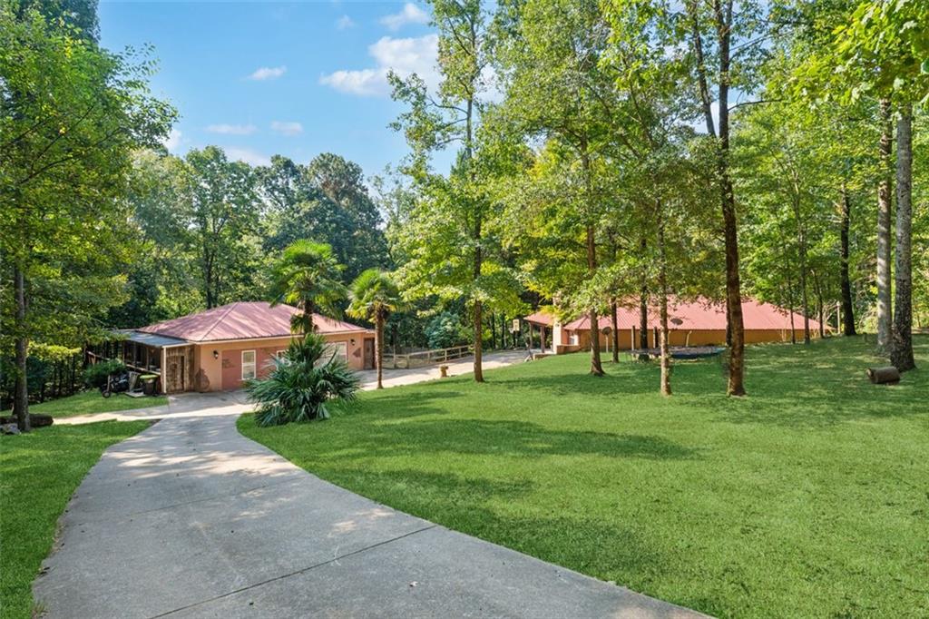 Two stunning and unique Spanish-style homes on a private 10.43-acre wooded estate with a creek. The main house is a single-level, step-free sanctuary featuring a grand master suite with a garden tub, a spacious walk-in tile shower for two, and an enormous walk-in closet complemented by two additional smaller closets. The living room boasts a cozy fireplace and an open, flowing floor plan. The kitchen includes stainless steel appliances, granite countertops, and a wet bar. Large windows frame serene views of the courtyard, while paint and concrete stained floors add modern charm. Outside, enjoy a covered patio perfect for relaxing or entertaining.
The guest house offers two bedrooms and one bathroom, a large kitchen open to the living area, and a fantastic wrap-around sunroom with a deck overlooking the creek.
A gated entrance and a long concrete driveway lead to the homes, creating your own private paradise perfect for entertaining and peaceful living.