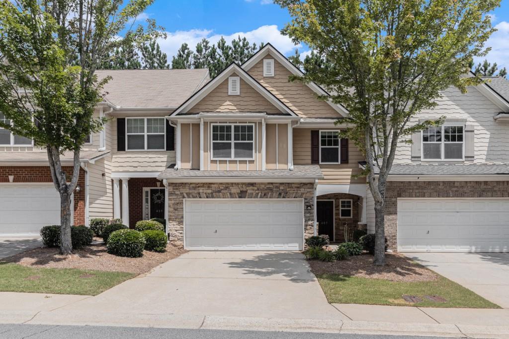 Modern Comfort Meets Natural Charm in this Beautifully Updated Townhome, ideally nestled in the Heart of the Sought-After Mountain Brook Community Complete with Swim, Trails, and a Private Lake! Thoughtfully Maintained and Recently Upgraded, this home features a Fully Renovated Kitchen and New HVAC System, both completed in June 2025, offering peace of mind and stylish functionality for years to come. Step into a Bright and Open Main Level, perfect for both Everyday Living and Effortless Entertaining. The soaring Two-Story Living Room is filled with Natural Light from an Abundance of Windows and centers around a Cozy Gas Fireplace. The Spacious Dining Area highlights Timeless Details like Crown Molding and Wainscoting, while the Renovated Kitchen showcases Quartz Countertops, Stainless Steel Appliances, Freshly Painted Gray Cabinets, a Breakfast Bar, and a Walk-In Pantry. A convenient Main Level Half Bath adds everyday ease. Upstairs, the Oversized Owner's Suite provides a Serene Retreat with Trey Ceilings, a Spa-Inspired Bathroom complete with a Glass Shower and Bench, Double Vanity Sinks, and a Large Walk-In Closet. Two Additional Bedrooms and a Full Bath offer Flexibility for Guests, Family, or a Home Office. Step outside to enjoy a Private Walk-Out Patio and Grassy Yard ideal for Pets, a Garden, or Weekend Grilling. Additional Upgrades include a New Roof, Washer, Dryer, and Refrigerator all under 3 Years Old plus the Updated Kitchen and New HVAC System, just completed this year. Take in the Natural Beauty of the nearby Lake and Walking Trail, or enjoy Resort-Style Amenities including a Swimming Pool, Playground, and Miles of Trails. Conveniently Located near HWY 92 with Easy Access to 575 and 400, and just minutes from Downtown Woodstock, Roswell, and Marietta this is the Lifestyle You've Been Looking For.