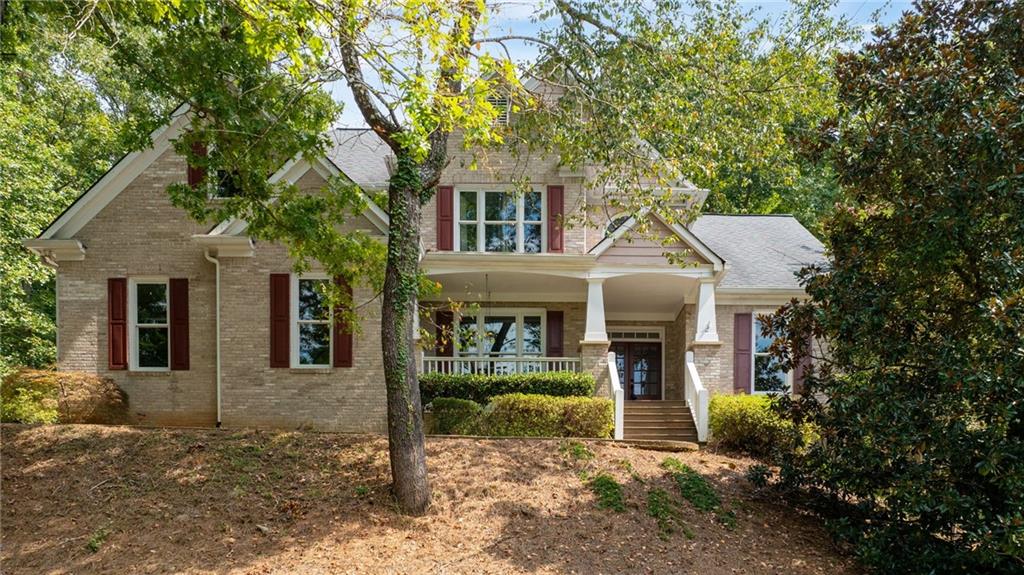 Tucked inside the highly desirable Sweetwater community near Lake Lanier, this spacious home offers exceptional privacy, everyday convenience, and a rare double lot totaling 1.43 acres. Surrounded by mature hardwoods, it provides the perfect blend of seclusion and neighborhood living.
From the moment you arrive, the welcoming front porch with a charming swing and double front doors set a warm tone. Step inside to find a formal dining room on the left and a formal living room or office on the right. Continue through to the two-story family room where a wall of windows fills the space with natural light, a classic brick fireplace adds warmth, and hardwood floors flow across the main level.
The kitchen features white cabinetry, granite counters, and stainless steel appliances, with open views to the breakfast area and family room so you can cook while staying connected. Host holidays in the separate dining room, and enjoy a quiet, tucked-away main-level office for work or homework. A full guest suite on the main level makes hosting friends and family effortless.
Upstairs, the oversized primary suite offers a cozy sitting nook framed by a bay window, tray ceilings, and his-and-hers closets. The bright bath includes two vanities, a separate tub and shower, vaulted ceilings, and abundant natural light. Two additional bedrooms share a full bath, providing ample room for family or guests.
The finished basement expands your living space with a full bedroom and bathroom, a second office, playroom, or hobby space, plus a large area ideal for a media room, man cave, or second living room.
Outside, a spacious tiered deck overlooks the private wooded lot—perfect for morning coffee, grilling with friends, or enjoying crisp fall evenings.
This home is ideally located just minutes from Lake Lanier, Buford Dam Park, and the Chattahoochee River trails, giving buyers easy access to boating, fishing, hiking, swimming beaches, and picnicking. The nearby Laurel Ridge Trail offers a scenic 3.8-mile hike with both lake and river views.
The Sweetwater neighborhood enhances the lifestyle with tennis courts, a clubhouse, and beautifully maintained grounds—all within a great school district.
With its spacious traditional layout, finished basement, multiple living spaces, and exceptional location, this warm, welcoming property is priced to sell and ready for your personal touch.