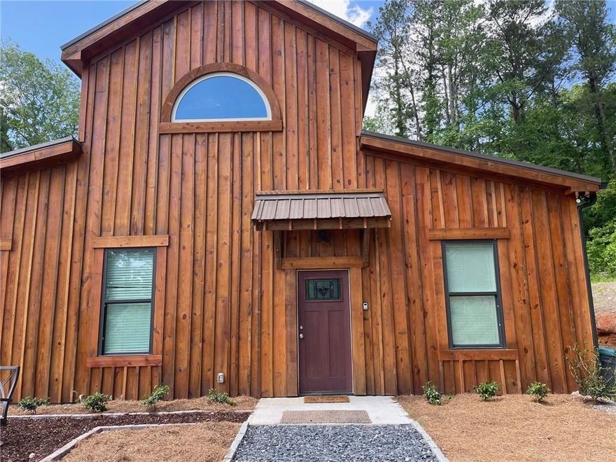 Discover the epitome of peaceful living in this enchanting lower level barn apartment nestled in the heart of a wooded wonderland. Offering a harmonious blend of modern elegance and rustic charm, this recently built 1 bedroom, 1 bath abode promises a lifestyle of comfort and serenity. Step inside to find yourself greeted by 800 square feet of thoughtfully designed and fully furnished living space. Every corner exudes warmth and sophistication, with high-end furnishings adorning the rooms, creating an ambiance of understated luxury. The well-appointed kitchen boasts all the essentials for culinary endeavors, complete with all appliances including refrigerator Prepare meals with ease while enjoying the soothing views of the surrounding foliage through oversized windows. After a long day, retire to the cozy bedroom for a restful night's sleep, lulled by the gentle whispers of nature outside your window. The adjacent bathroom offers a tranquil sanctuary, featuring modern fixtures and ample space for relaxation. Beyond the comforts of home, this retreat comes complete with the added convenience of a stacked washer and dryer. All utilities and high-speed internet are included, ensuring effortless living. A private entrance and parking ensures your peace and privacy. Situated in a breathtaking country setting, you'll relish in the seclusion and tranquility this locale provides. Yet, convenience is never compromised, with the renowned wellness community of Serenbe just a 6-minute drive away and easy access to I-85, placing amenities and attractions within easy reach. Embrace the opportunity to escape the hustle and bustle of city life and immerse yourself in the beauty of nature. Schedule a viewing today and experience the unmatched serenity and comfort that await in this captivating retreat.