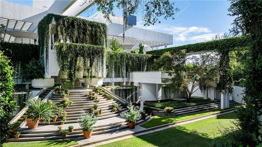 Nestled along the illustrious coastline of Sea Island, this exceptional residence by the eminent architect John Portman is an embodiment of modernist philosophy and an exemplar of the ‘Entelechy’ concept—a state in which potentiality reaches its fullest realization. This residence transcends the conventional, standing as a harmonious interplay between architectural form and the natural grandeur of its oceanfront setting. Portman’s genius is evident in the meticulous orchestration of space, light, and materiality. Expansive glass façades blur the demarcations between interior and exterior, inviting the serene panorama of the Atlantic Ocean into every room. The soaring volumes and fluid transitions between spaces evoke a sense of grandeur and openness, where each architectural element is conceived not just for its aesthetic merit but as part of a holistic experience. The residence captures the very essence of coastal modernism, where the ebb and flow of the ocean find their reflection in the dynamic forms and tranquil atmospheres within. The home’s interiors are a study in sophistication and restraint, with a palette of materials selected to echo the natural surroundings while asserting a timeless, yet progressive, elegance. The interplay of light and shadow across the curated finishes creates an environment that is at once meditative and inspiring, embodying Portman’s vision of architecture as a lived art form. This aesthetic is reminiscent of his work on Entelechy I and II, where the synergy between the built environment and its context elevates the residence from mere habitation to an immersive, sensory experience. Set against the pristine backdrop of Sea Island, the residence offers a rarefied living experience that is as much about embracing the natural splendor of the coastline as it is about dwelling within an architectural masterpiece. Here, the rhythmic sound of the waves and the ever-changing hues of the seascape become an integral part of the home’s essence, enriching daily life with moments of quiet reflection and awe. In addition to the main residence, the property includes a private guest cottage featuring 4 bedrooms, 3.5 bathrooms, and 3,432 square feet. Not included in the main residence’s bedroom count or square footage, this cottage serves as an ideal space for accommodating additional guests, offering privacy and comfort while preserving the residence’s serene connection to the surrounding landscape. This is not merely a home; it is a sanctuary of enlightened living, where every design decision has been made with an eye toward creating a seamless dialogue between the structure and its surroundings. It stands as a testament to Portman’s architectural legacy, a rare opportunity to reside in a space where the boundaries between art, architecture, and nature dissolve into a unified, transcendent experience.