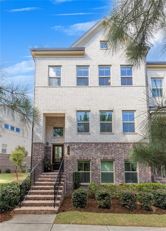 Beautifully built by Lennar, this townhome is located in the highly desirable community of Haddonstone, just minutes from the vibrant heart of Downtown Woodstock. Offering a perfect blend of comfort, convenience, and style, the thoughtful design and prime location make this home truly special. The spacious main level showcases an open-concept layout with a family room featuring a cozy fireplace framed by custom built-ins, seamlessly flowing into the dining area and a stunning kitchen. The kitchen boasts a large center island with seating, white cabinetry, and stone countertops. Just beyond, a bright and airy breakfast area offers flexibility as an additional dining space, home office, or reading nook. A keeping room off the kitchen provides the perfect spot to relax and offers direct access to the covered deck—ideal for enjoying morning coffee or dining al fresco. A convenient guest powder room completes the main level. Upstairs, the oversized primary suite impresses with a tray ceiling, sitting area, and walk-in closet. The ensuite bath features dual vanities and a glass-enclosed walk-in shower, creating a spa-like retreat. Two additional generously sized bedrooms share a hall bath, and a laundry room is ideally located on this level for everyday ease. The lower level includes a two-car rear-entry garage with a practical drop zone, as well as a light-filled bedroom and full bath, perfect for guests seeking privacy. This end-unit home is also situated next to a green space, ideal for play or walking your dog, and in close proximity to guest parking, making it especially convenient for visitors. Living in Haddonstone means enjoying a low-maintenance lifestyle with exterior upkeep and landscaping included. Neighborhood amenities include a sparkling pool and clubhouse, while the community’s prime location offers easy access to I-575 and the express lane for smooth commuting. Just minutes away, Downtown Woodstock awaits with its charming shops, restaurants, entertainment, and access to the expansive Greenprints Trail system. Discover why this thriving North Georgia town is one of the region’s most sought-after places to call home.