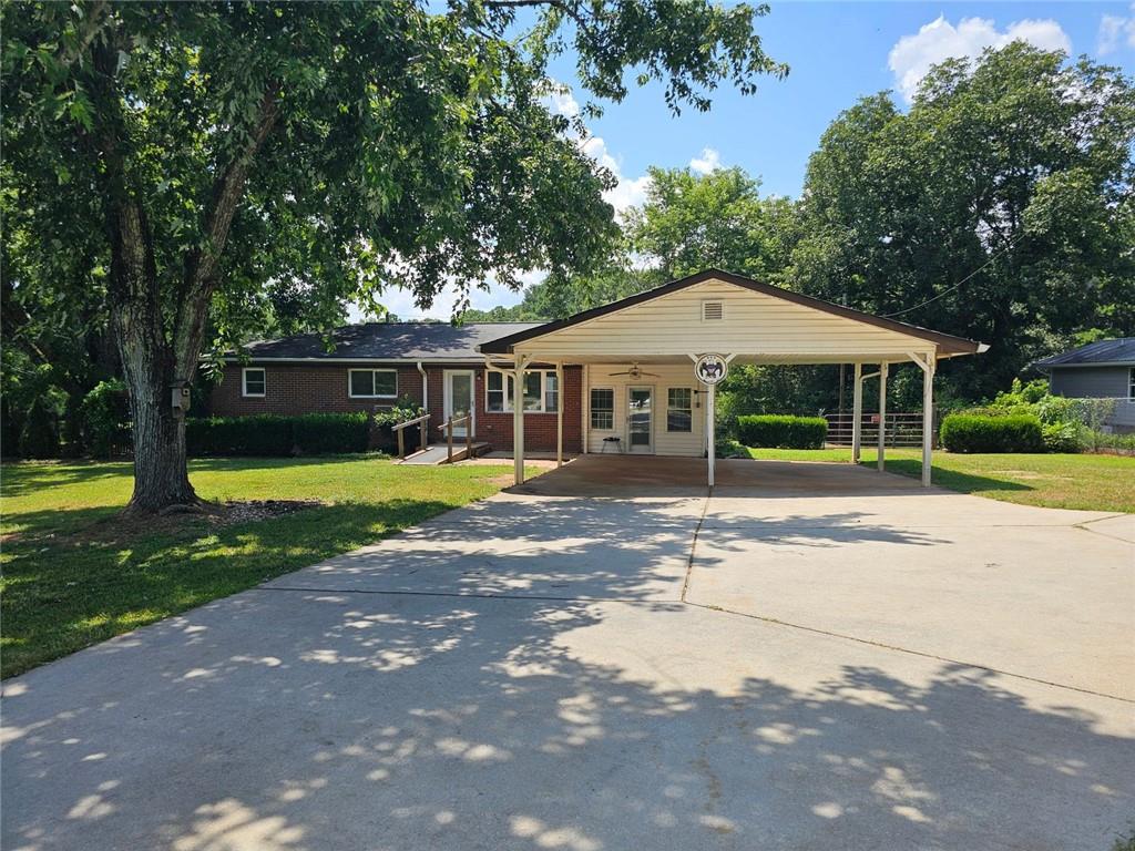 This 2-bedroom, 1.5-bath ranch-style home offers the perfect blend of privacy, functionality, and potential. Nestled on nearly 2.5 acres of open, level land with well-maintained landscaping, this property is ideal for first-time buyers, hobbyists, or anyone looking to downsize while still having plenty of room for storage and projects.
The home features vinyl flooring throughout, modern appliances, and a recently upgraded HVAC system (6 years old) along with updated electrical. The original one-car carport has been enclosed to create a spacious bonus room — perfect as a third bedroom, home office, or flex space. A covered two-car carport was added, providing plenty of parking and shelter from the elements. The back deck needs a little TLC but is spacious with an added room that has a hot tub for relaxing in privacy. At the back of the property, a large 30' x 50' building offers incredible workshop potential. Fully equipped with power and water, the building includes a piped-in air compressor system, making it ideal for automotive work, woodworking, or any project requiring tools and space. While the house and building could use some cosmetic updates and a bit of TLC, the solid bones and unbeatable location — with convenient access to Douglasville, Newnan, Carrollton, and Hartsfield-Jackson Airport — make this a fantastic opportunity to create your perfect home base. Perfect opportunity for someone looking for a home to fix the deferred maintenance and make it their own. Motivated seller!!! Schedule your showing and lets work out a great deal for this amazing property. The land the property sets on is hard to come by. What an amazing opportunity to have your little slice of heaven.