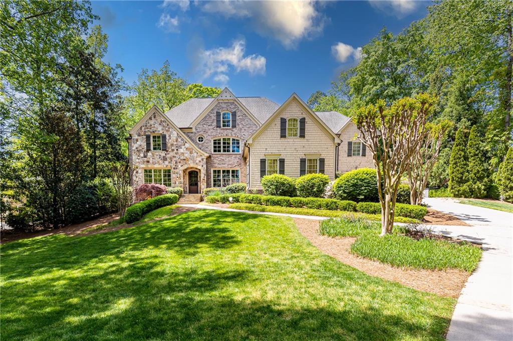 Surrounded by 20 acres of a wooded park, this custom home on more than 1 acre, designed by William Stewart, offers an exquisite blend of form and function in a private yet incredibly convenient setting. The walk-out flat backyard features an elegant pool and hot tub with soothing waterfall feature, a firepit and a pool house with full bath and dining area (all added in 2012). Inside, the six bedrooms include ensuite bathrooms and walk-in closets, with the primary suite featuring a generous sitting room and two tremendous walk-in closets. High-end details are everywhere, including a custom-designed wrought iron railing on the continuous three-level staircase; quarter-sawn hardwood floors on the first and second levels; built-in bookshelves and desks; overly generous, discreet storage throughout the home; and so much more. The custom kitchen by Design Galleria features a Sub-Zero refrigerator and two refrigerator drawers; a Dacor six-burner cooktop; two full-size JennAir ovens; a warming drawer; two full-sized dishwashers; and a walk-in pantry. Special features include a two-story living room with sophisticated centerpiece fireplace; gorgeous dining room; a large, informal keeping room attached to the kitchen; a study; mudroom with built-in cabinets; screened porch with fireplace, vaulted ceiling and wooden beams; formal and informal powder rooms; two laundry rooms; and a three-car garage with electric car charger. In addition, you'll love the huge finished basement with unusually high 10-foot ceilings featuring a large TV room; workout room furnished with professional fitness equipment; art/craft/hobby room; bedroom with ensuite bathroom; an additional half bathroom; and a giant unfinished storage area. This meticulously maintained home is a unique, high-end, livable treasure ideally located on a quiet, dead-end street in Sandy Springs with convenient access to everything!