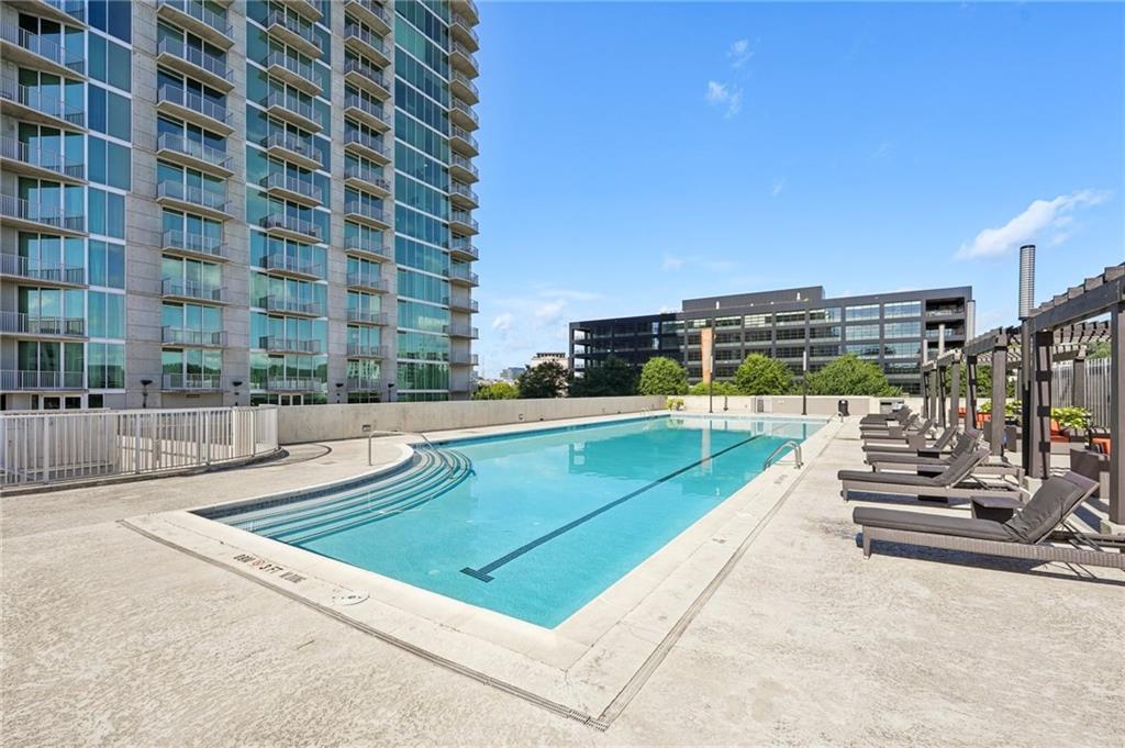 Live in the heart of it all in an iconic high-rise offering luxury living and unbeatable walkability with a Walk Score of 89! This well-maintained 2-bedroom, 2-bath condo is the perfect blend of comfort, style, and convenience, with bright open spaces and sophisticated finishes throughout. Step inside to discover gorgeous hardwood floors across the entire unit—no carpet anywhere! The open-concept kitchen is both stylish and functional, featuring granite countertops, a breakfast bar, tile backsplash, and stainless steel appliances, including a brand-new oven. Just off the kitchen, the dining area offers a welcoming space for meals. A built-in desk nook makes working from home easy and efficient. The spacious living room is flooded with natural light, thanks to floor-to-ceiling sliding glass doors that open to a private balcony stretching the full length of the home—perfect for enjoying city views and fresh air any time of day. Designed with privacy in mind, the split-bedroom floor plan is ideal for roommates, guests, or a dedicated home office. Both bedrooms feature floor-to-ceiling windows, generously sized closets, and en-suite bathrooms with granite-topped vanities and modern finishes. The unit also boasts 2 parking spots and fresh interior paint, making it truly move-in ready. Enjoy resort-style amenities, including a 24-hour concierge, fitness center, and rooftop pool with sundeck. Located directly across from Atlantic Station, you'll enjoy instant access to some of Atlanta’s best shopping, dining, entertainment, parks, and more—all just steps from your door. Whether you're looking for a stylish city retreat or a vibrant urban lifestyle, this stunning home delivers on all fronts. Don’t miss your chance to live in one of Midtown’s most desirable addresses!
