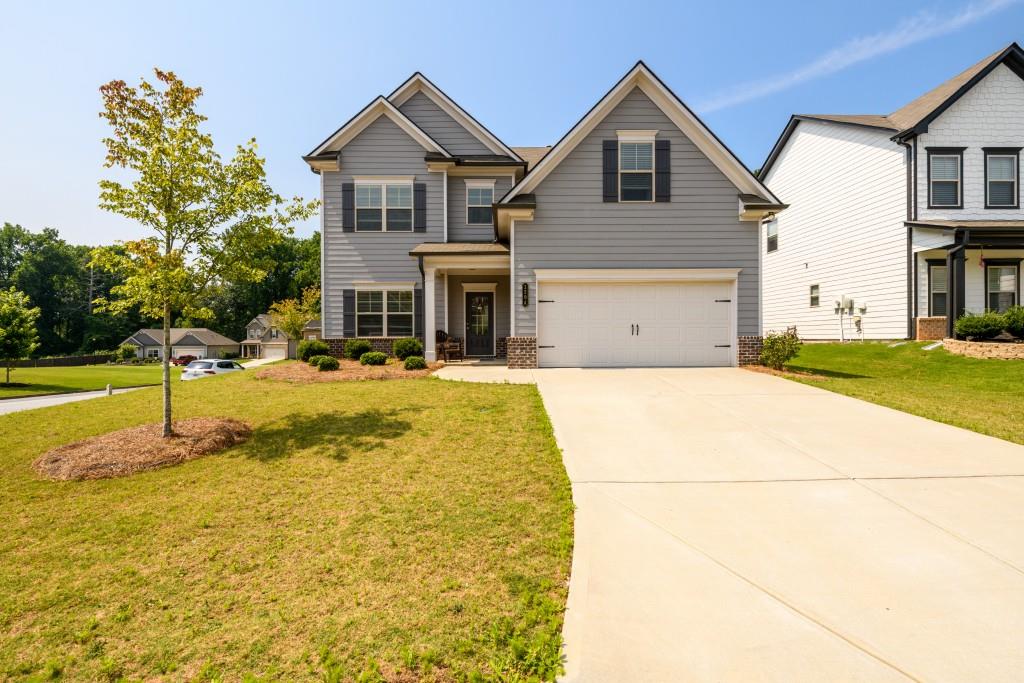 Lovely 5-bedroom 3-full bath home with bedroom and full bath on main. Minutes from downtown Hoschton in sought-after Jackson County schools. Living room/office or flex room off foyer entry. Gorgeous bright and open kitchen with breakfast bar, large island, eat-in kitchen, and walk-in pantry. S/S appliances & gas stove. Large family room with coffered ceiling, fireplace with gas logs and open to kitchen. Built-in drop zone off kitchen and garage providing the perfect place to keep all things organized. Primary bedroom is large with trey ceiling and sitting area. Primary bath with double vanities, water closet, large shower, and access to huge walk-in closet. All secondary bedrooms are large with great closet space. Spacious corner lot on cul-de-sac street with full privacy-fenced backyard, and open green space across the street for more room to roam. Brighton Park community offers a playground, clubhouse, pool and kitty pool with mushroom water feature.