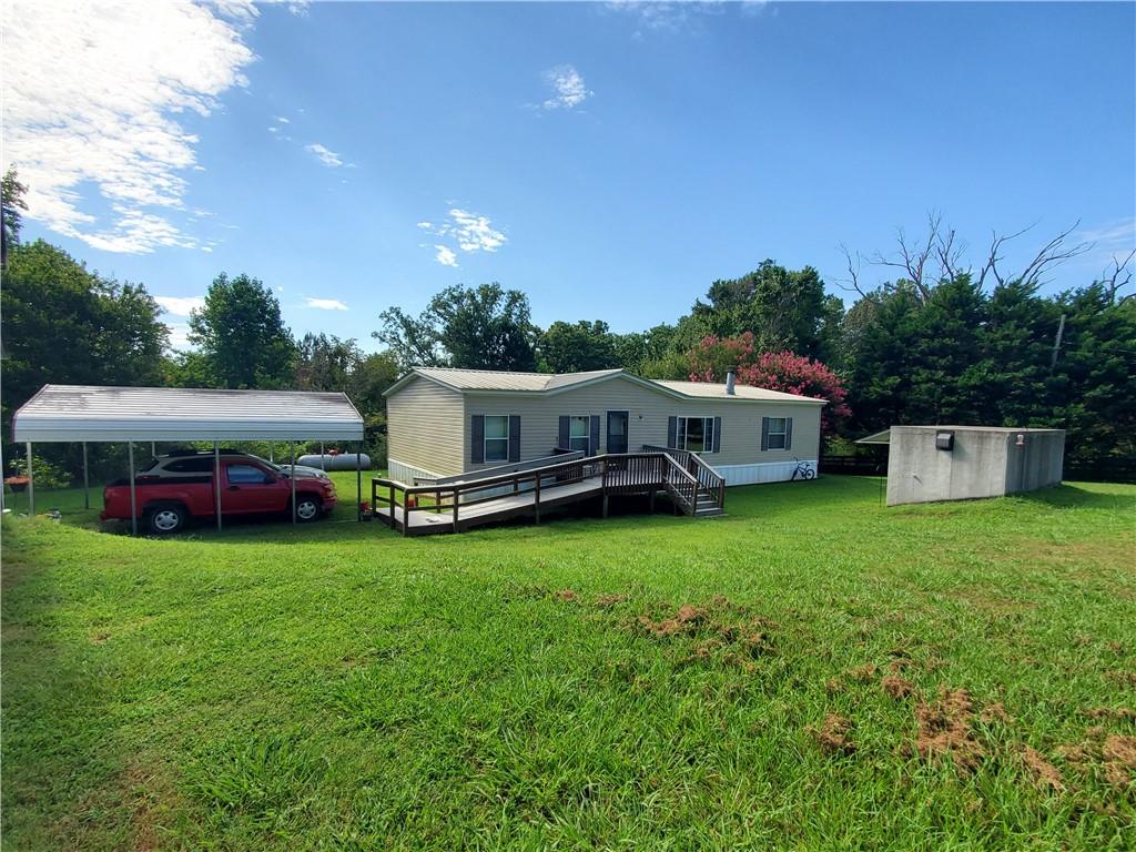Lovely private property in the country. 4 acres to stretch out on with a small Spring fed pond. Doublewide has been well maintained. Wood burning fireplace. Lg great room, dining and kitchen. Best looking storm shelter I've ever seen. Nice sized Barn & workshop. Property has setup ( water, power, and septic) for a home to be built or put another mobile home. Tons of possibilities with this one. Doublewide sits on a slab. If needed, Owner will have it blocked after Due Diligence and before closing.