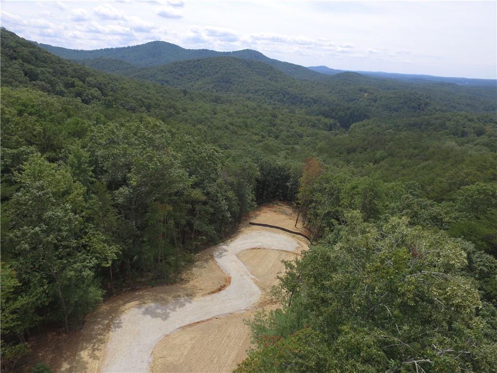 "Dream View" lot just waiting for your dream home! This gorgeous, private 6+ acre lot has been cleared to reveal the most amazing view and to make way for your mountain getaway or full-time mountain home. Get a head-start on building--the homesite is cleared and graded, the driveway is in, septic is in, erosion control completed, and grass is planted! Located in Stonecrest, surrounded by million-dollar homes, and just minutes from downtown Ellijay, you couldn't ask for a better location. This land is tucked away in a serene mountain setting but still close to all the best shopping, dining, and recreation Ellijay has to offer. Enjoy weekend brunch or a gourmet dinner just minutes from your door at the new Falls at Blue Ridge restaurant. Endless adventures await you at Carters Lake, Rich Mountain, Cohutta Wilderness, and Amicalola Falls. You're also close to what Ellijay is famous for--its apple orchards and the Ellijay Apple Festival! Blue Ridge is just a short scenic drive away as well as Blairsville and other quaint mountain towns. Stonecrest has no HOA, only minimal covenants in place to protect the integrity of the community such as maximum number of homes per acre, no mobile homes, minimum home size, etc. Short-term rentals are allowed. Power and fiber are available at the cul-de sac at the top of the driveway.