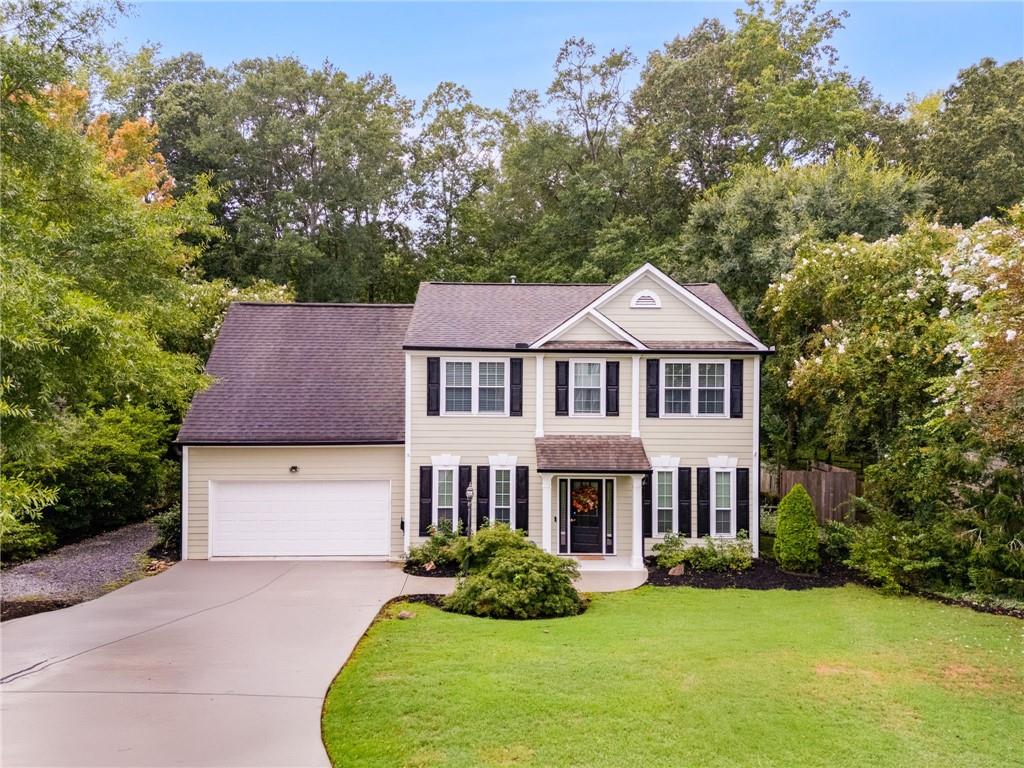 Love the traditional curb appeal, but not a traditional floorplan? This home will WOW you with almost 3,300 sq ft, a spacious, open floorplan with a freshly painted interior, 5 bedrooms, including a large bedroom suite on the main level, 3 full bathrooms, and a 1/2 bath for guests. This home loves gatherings with friends & family! As you enter, you'll find a study/office and a dining room with chair rail, open to a beautifully updated kitchen with soapstone countertops, stainless steel appliances, extensive cabinetry with pull out shelving and soft close doors & deep drawers, built-ins, a tile backsplash, pendant lighting, dry bar, and extended, marble-topped island with pendant lights, fronting to a spacious keeping room with a beamed/coffered ceiling. The adjacent family room features hardwood floors, high ceiling with wainscotting and recessed lighting, a pretty, boxed recess with floor to ceilings windows, and loads of natural light. Off the family room, you'll find the first bedroom with an impressive, barrel ceiling, fan, tiled flooring, walk-in closet, and an elegant ensuite bathroom. A laundry room, powder room, and two-car garage complete the main level. Upstairs, retreat to the rest of the bedrooms, including the primary suite dressed with extensive crown moulding, deep trey ceiling, fan, walk-in closet, and ensuite bathroom with double vanity, soaking tub, and separate shower. The secondary bedrooms will delight as well - one features a built-in bunk, one a game room AND bonus space, and one has a dreamy ceiling of clouds. All have ceiling fans. The secondary bathroom offers tiled flooring, a double vanity, and shower. The backyard is made for fun and relaxing gatherings, too. The side courtyard patio is perfect for outdoor dining and leads down to a large firepit flanked by large stones. Imagine having your own basketball court! And a workshop! All this and still plenty of room to play. The neighborhood provides a swimming pool and community lake with a fishing dock. Perfect location with reputable schools and a short drive to shopping, restaurants, and parks.