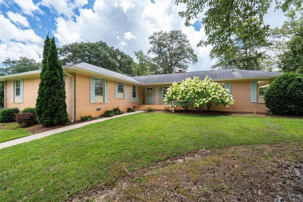 Classic and Large 4 sided brick ranch! Right in the beautiful town of Douglasville! Walking distance to Douglas County High School, Downtown and all the fun activities Douglasville hosts each season. Great restaurants and the new amphitheater are just a short walk on the tree lined sidewalks through the towns' historic district. 4 bedroom and 2.5 baths. Eat-in kitchen, dining room, living room and family room with wood burning fireplace. Slate foyer and hardwood floors! They don't make homes like this one any more! This is a one owner home that has been lovingly cared for all its' years and is waiting for a new family to live their best life here too.