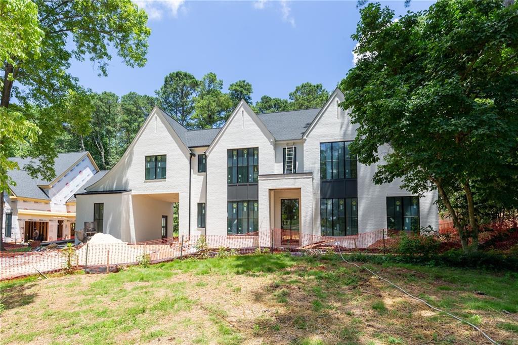 Experience elevated living in this luxury new construction home, perfectly positioned in the heart of Alpharetta's "Garden District" This spectacular residence features 5 bedrooms, 5.5 bathrooms, a 3-car garage, porte cochère, and a sought-after owner’s suite on the main level—an ideal layout for sophisticated living. A covered front entry with gas lanterns opens to a dramatic two-story foyer. Inside, 12-foot ceilings and hardwood floors flow throughout the main level. A private office and powder room sit just off the entry. The main-level owner’s suite features vaulted ceilings, a spa-like bath with a freestanding tub, frameless glass shower, dual vanities, and a spacious wardrobe closet. The gourmet kitchen boasts top-tier appliances, a large island, custom range hood, and a separate catering kitchen/pantry. A breakfast room flows into the family room, complete with a fireplace and built-in shelving. Just off the kitchen, a mudroom includes custom lockers and hooks for daily convenience. Upstairs you'll find a generous loft, a second owner's suite with dual walk-in closets and a beautifully finished bath, plus three additional en-suite bedrooms with walk-in closets. A full laundry room is also located upstairs. Enjoy year-round outdoor living with a covered fireside lounge and space planned for a FUTURE POOL. All this just steps from the shops, restaurants, and energy of Downtown Alpharetta—walkable to weekend events, music, and local charm.