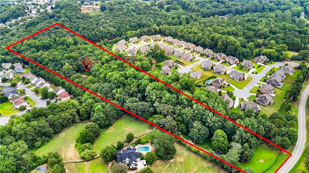 Incredible 13.5-Acre Opportunity in Prime South Forsyth Location! Located in a high-demand area experiencing rapid residential growth, this expansive 13.5-acre property offers 196 feet of road frontage and full utility access, including sewer. The land has already been subdivided into 4 lots, with the ability to build 2 homes per lot without rezoning—ideal for developers or investors. A charming cabin which has 4 bedroom 2.5 bath in the main house and 1 bedroom 1.5 bath apartment above the garage (currently tenant-occupied) sits on the property and can be transformed into a unique short-term rental or guest house. With top-rated Lambert High School zoning, this property is a rare find with endless potential—whether you're building a private enclave, investing in rentals, or holding for future appreciation. Don't miss this incredible opportunity to own a large tract of land in one of Forsyth's most sought-after school districts!