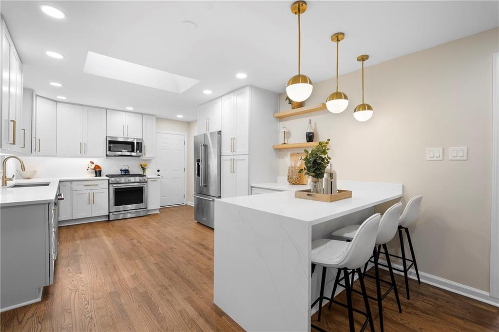 STUNNING remodeled in Sagamore Hills!! This four sided brick home in sought after Sagamore Hills has been completely reimagined with timeless style and modern finishes. The heart of the home is the brand new kitchen with 42 inch cabinets, quartz countertops, a matching quartz backsplash, a large island with seating, and premium KitchenAid stainless steel appliances. Open living areas flow seamlessly with refinished solid hardwood flooring, abundant natural light from all new windows, and a cozy gas fireplace in the main living room. A formal dining room provides an elegant space for entertaining while recessed lighting and new fixtures add a fresh contemporary feel throughout. The owner’s suite is a private retreat with a marble vanity, a beautifully tiled shower with floor to ceiling detail, and a custom walk-in closet with built-in shelving. Secondary bedrooms feature custom closet organizers, and all bathrooms have been refreshed with marble countertops and stylish finishes. The lower level expands your living space with epoxy flooring, a laundry area, and flexible semi finished rooms that can serve as an office, recreation area, or gym, with ample storage throughout. With 1897 square feet above grade and an additional 1897 square feet below grade, the home offers both sophistication and versatility. Outdoors, the freshly painted exterior and new driveway create a crisp modern presence. The carport has been refinished with epoxy, landscaped grounds offer curb appeal, and the backyard is a true escape with a treehouse and sitting area, a spacious deck, and a lower terrace with a granite outdoor fireplace. Additional highlights include a Nest thermostat, new exterior doors, updated electrical, and modern light fixtures throughout. Nestled in a neighborhood known for top ranked schools and its proximity to Brookhaven, Northlake, Toco Hills, Children’s Healthcare of Atlanta, Emory, and the CDC, this location is truly unbeatable. Just minutes from vibrant restaurants, shops, parks, museums, and major highways, it offers a connected lifestyle with endless convenience. Welcome home to modern luxury blended effortlessly with classic charm.