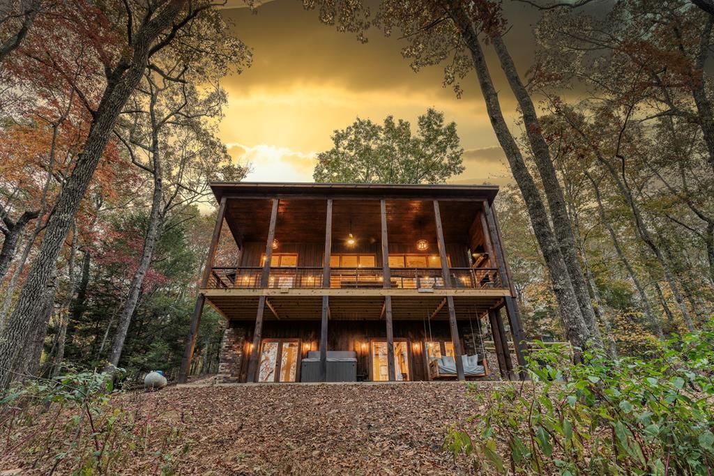 Turnkey rental investment or vacation home, averaging over $90k in gross revenue. This 3-bedroom, 3.5 bath modern chalet style home has been thoughtfully designed for both comfort and investment. The main level features an open-concept living space with vaulted ceilings, a cozy gas fireplace, and a fully equipped kitchen with a large island, dining area, and powder room. The main-level primary suite includes a king bed, attached bath with double vanity, and a luxurious tiled shower with rainfall head. Downstairs, the terrace level is made for entertaining, with a game room complete with wet bar, foosball table, arcade game, and smart TV. You'll also find two additional bedrooms (one with twin-over-twin bunks, one with a king bed), two full bathrooms, and a sleeper sofa. Outdoor living is just as impressive, with a spacious main-level deck offering ample seating, a wood-burning fireplace, TV, and picnic table. The lower patio includes a 5-person hot tub, swinging daybed, and a fire pit, ideal for cool mountain evenings. Whether you're looking for a successful short-term rental investment or a relaxing second home in the mountains, this well-maintained property is ready to go. Cabin is fully turnkey with all furnishings, decor, supplies, and marketing included. Current owners have over 100 5-star reviews and are willing to stay on as co-hosts to help the new owner continue the
success of Chardonnay Chalet. Showings by appointment only, do not disturb guests. Please see the documents section for Airbnb link, rental history, and average expenses.