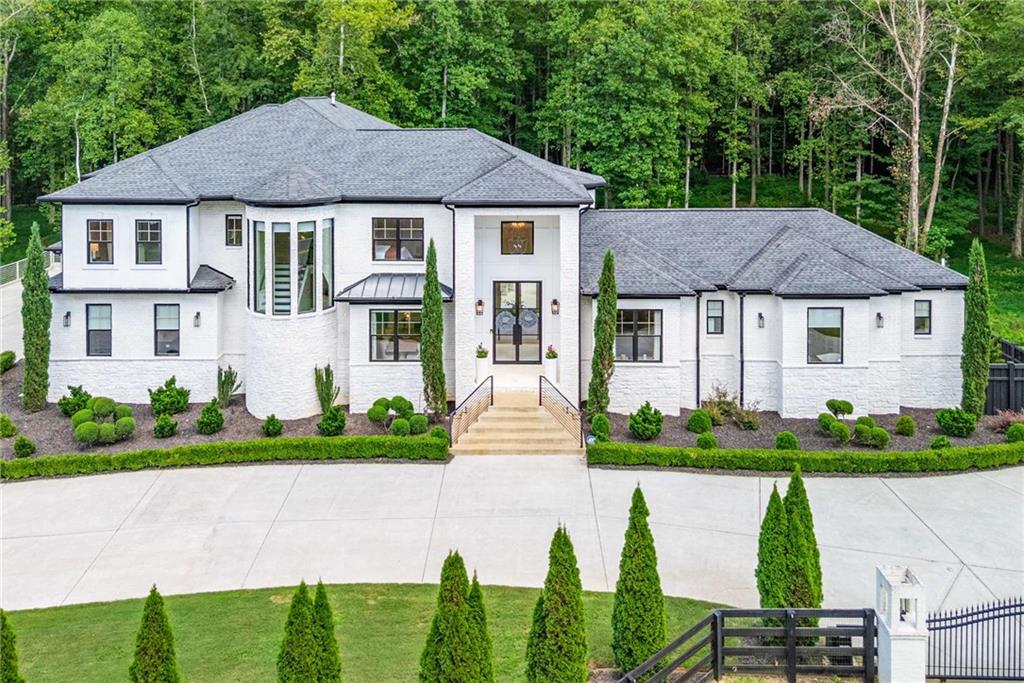 Welcome to a Milton masterpiece! Situated on 4 acres, this sprawling property has been modernized throughout with first class upgrades and designer finishes. 20-foot ceilings greet you at the door and into a spectacular open concept living oasis. With just under 10,000 square feet of living space 14225 Birmingham Highway delivers exceptional living at its finest. Custom finishes in the kitchen include a waterfall quartz finished island, elite cabinetry, ILVE Italian 7-burner stove, Sub-Zero refrigerator, and a stunning paneled walk-in pantry. Floor to ceiling windows in the main living space create an incredible backdrop to forestry and complete privacy. Natural light is in abundance as you transition out to the resort style outdoor pool and patio. Two Primary suites are featured in this home, on the main, and upstairs. Both with fireplaces and exquisite spa-like bathrooms. The primary suite upstairs features a large living room with glass French doors overlooking the pool. A completely refinished basement includes a new kitchenette, living room, recreational space, a new screened in porch for entertaining, full bathroom, sauna and fitness center. This incredible property is gated with a three-car garage, enough room to park an abundance of cars, and enough land to disconnect from the world and celebrate life. Come see this remarkable property, it is yours for the taking!
